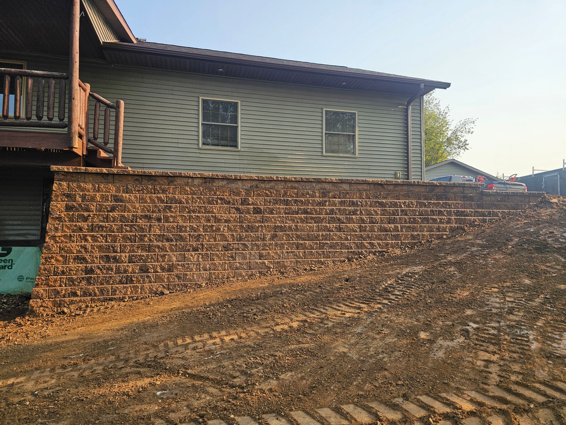 A house with a brick wall in front of it.