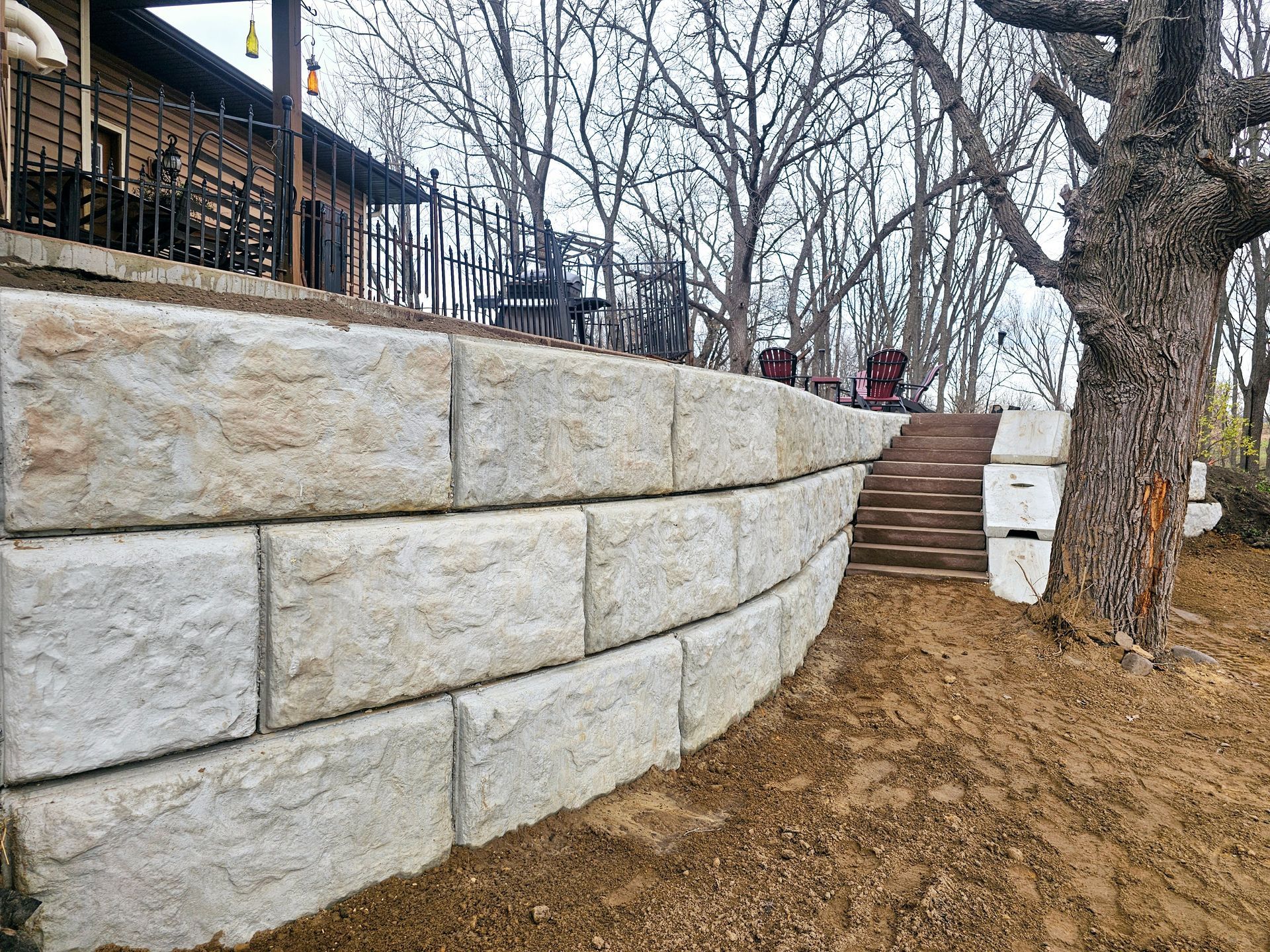 A stone wall with stairs leading up to a house.