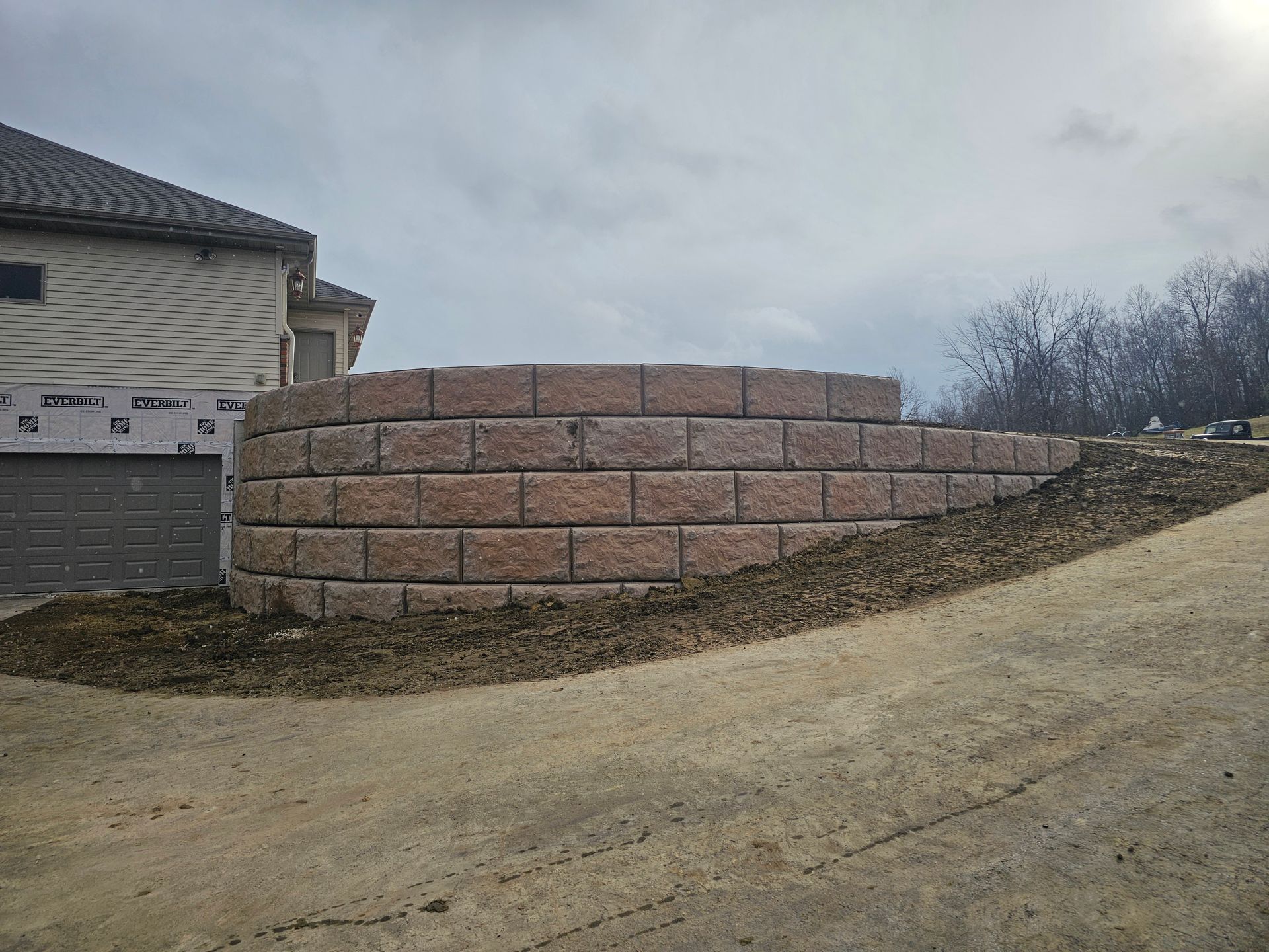 A brick wall is being built in front of a house.