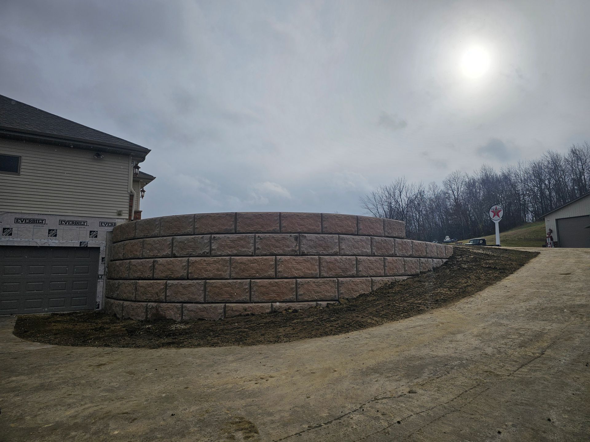 A brick wall is being built in front of a house.