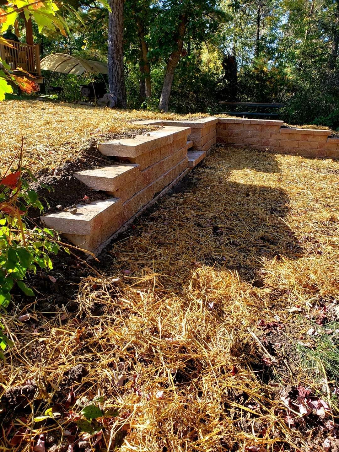 A brick wall with stairs leading up to it in a yard.