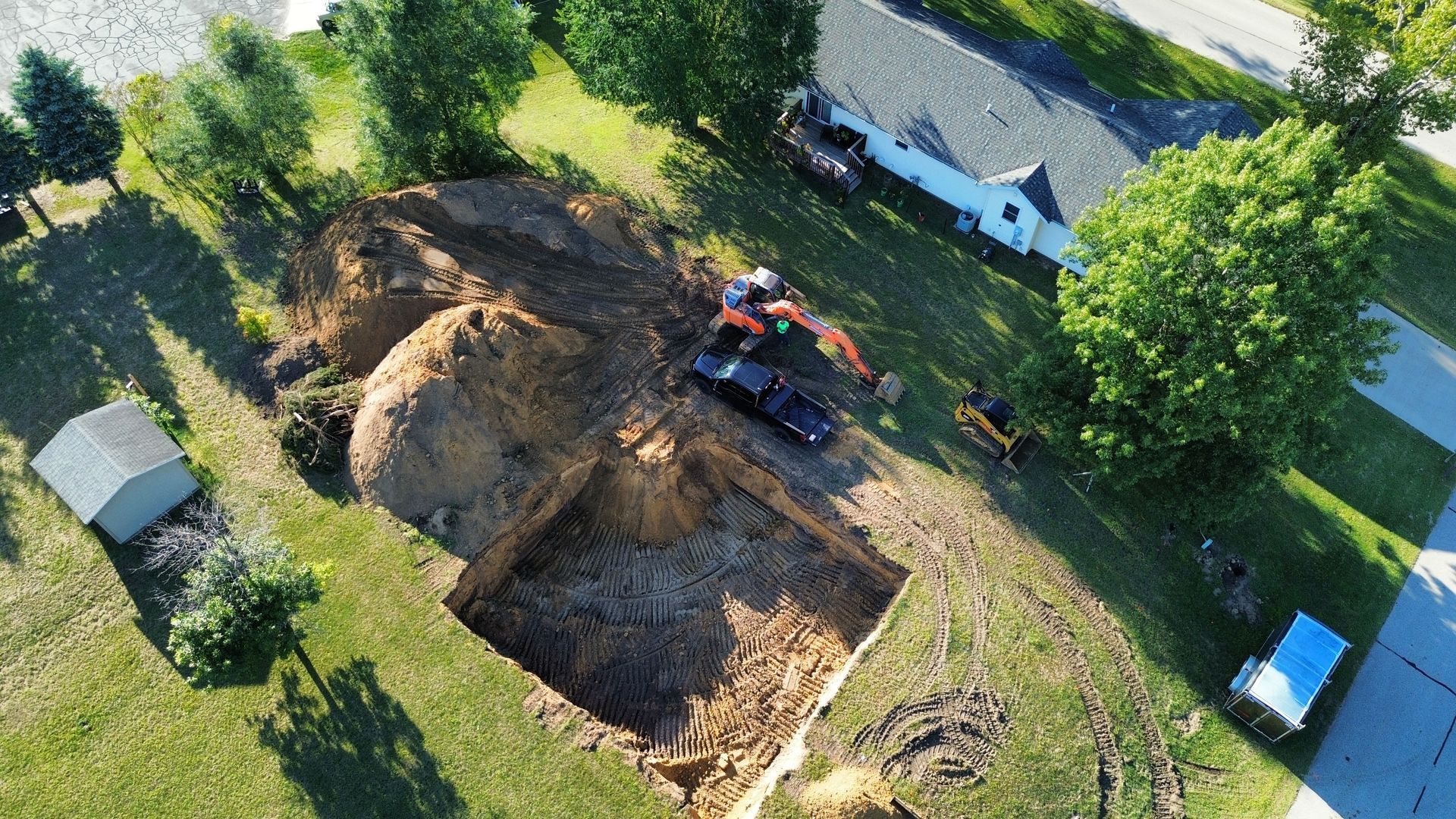 An aerial view of a construction site in front of a house.
