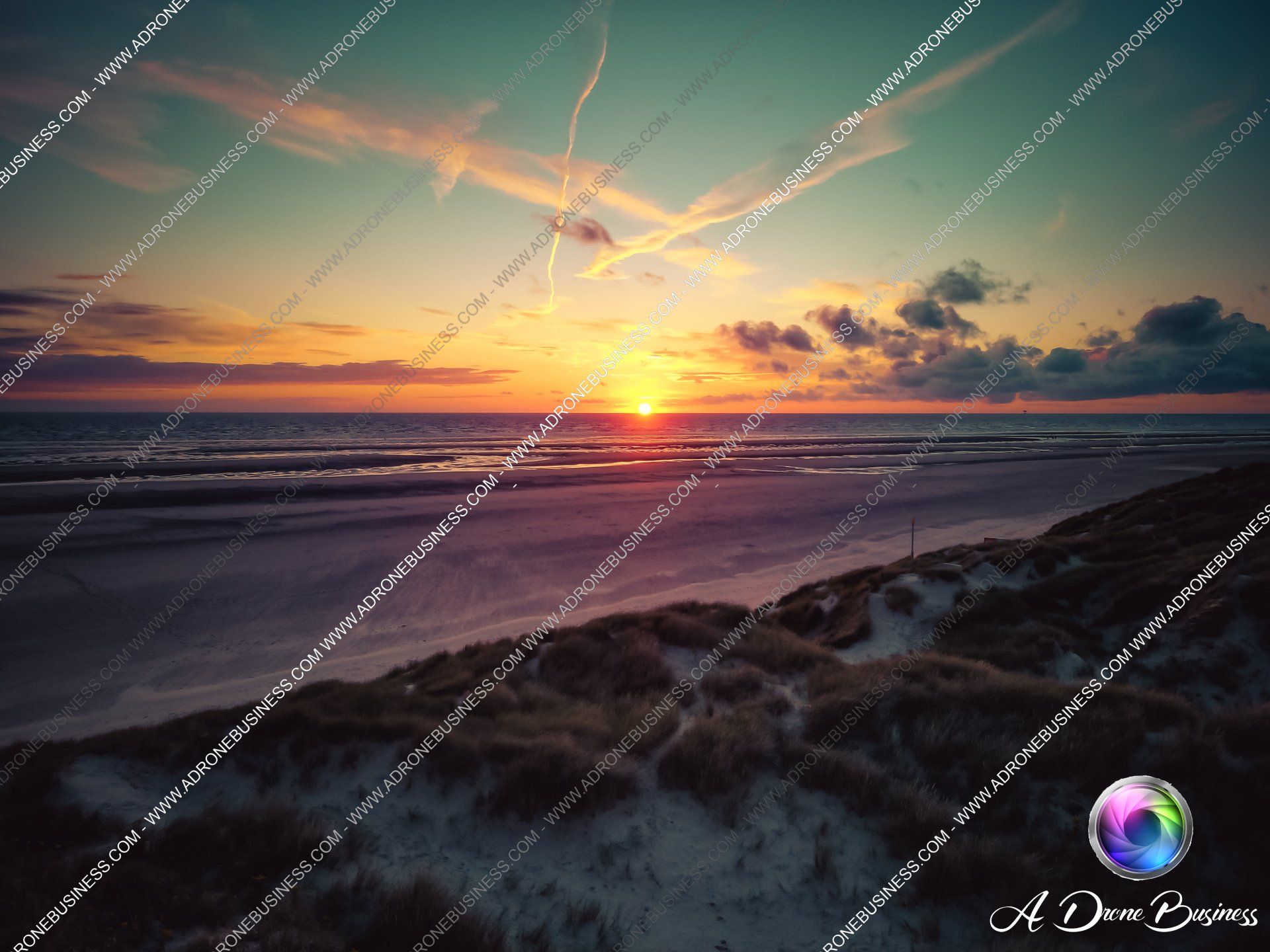Sunset falling over the empty beach of Formby, with cloud silhouettes