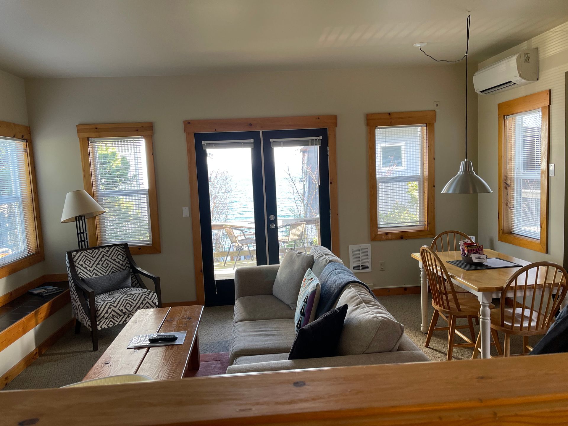 A living room with a couch , chair , table and windows.