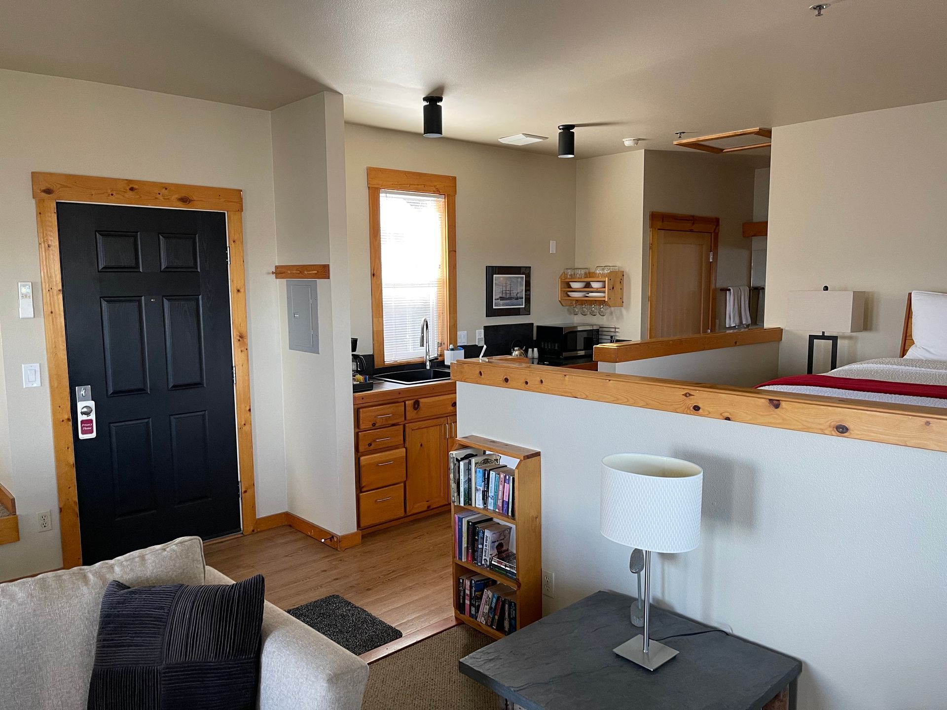 A living room with a couch , table , lamp and bookshelf.