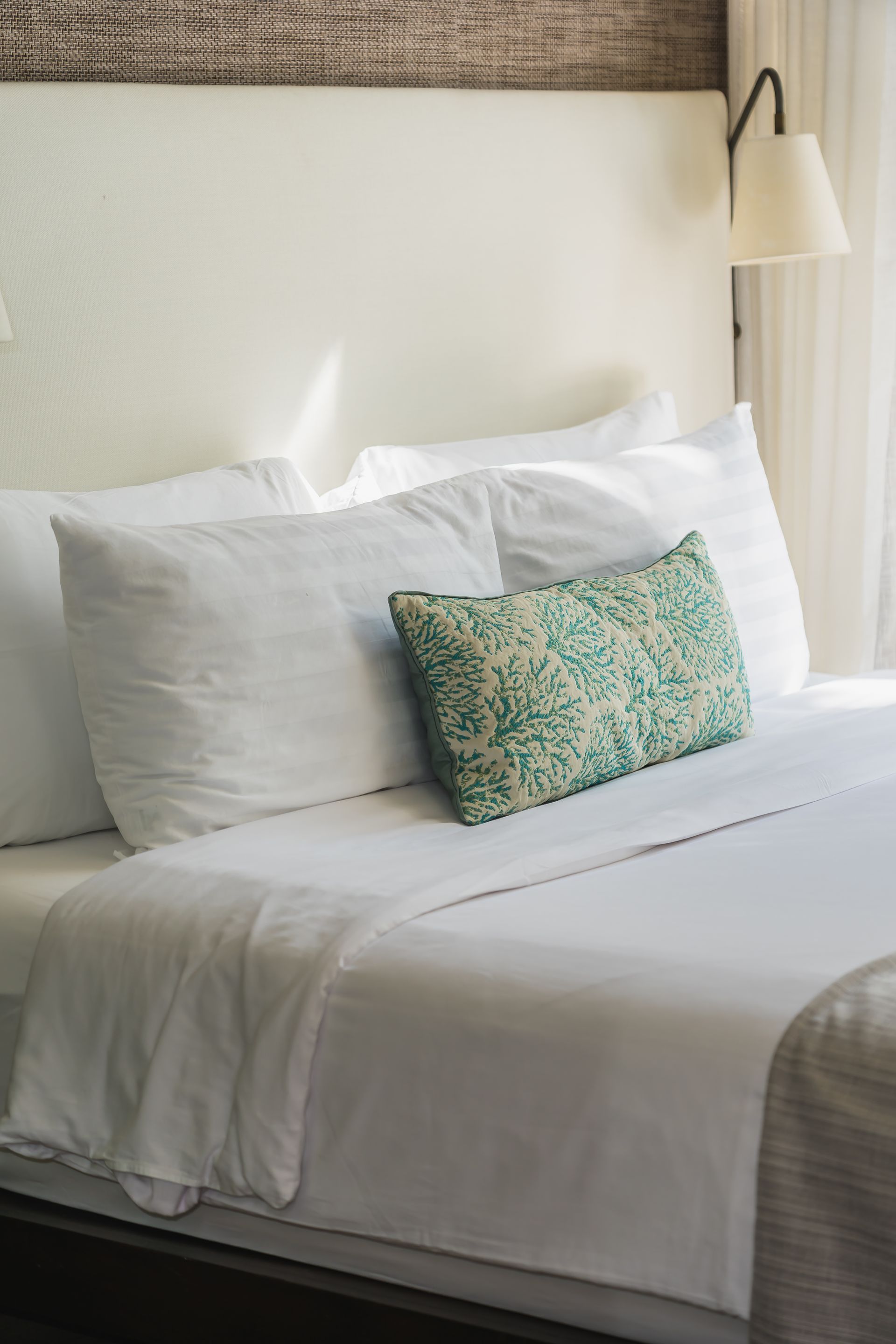 Cama con sábanas blancas y almohadas.