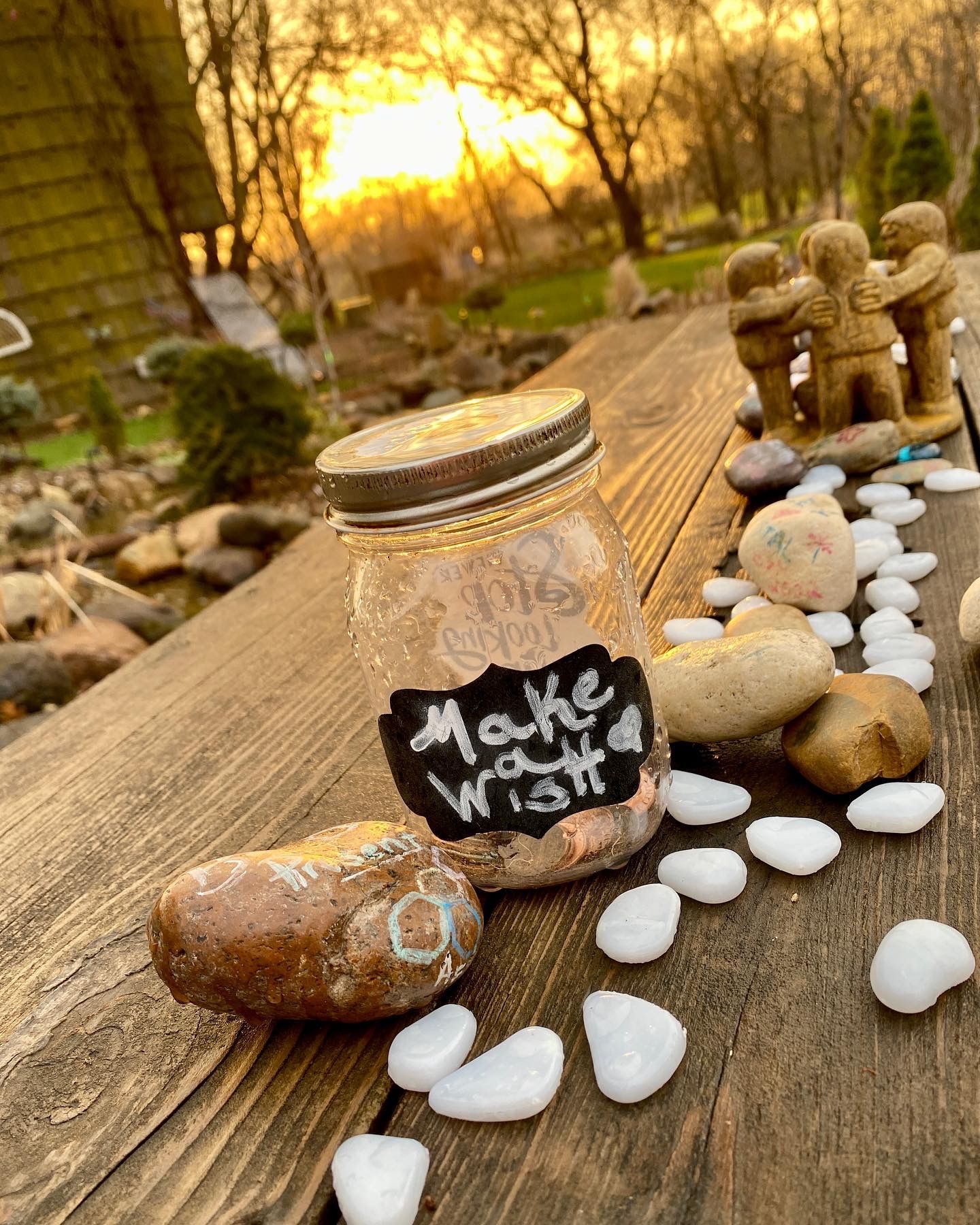 A mason jar sitting on top of a wooden table surrounded by rocks.