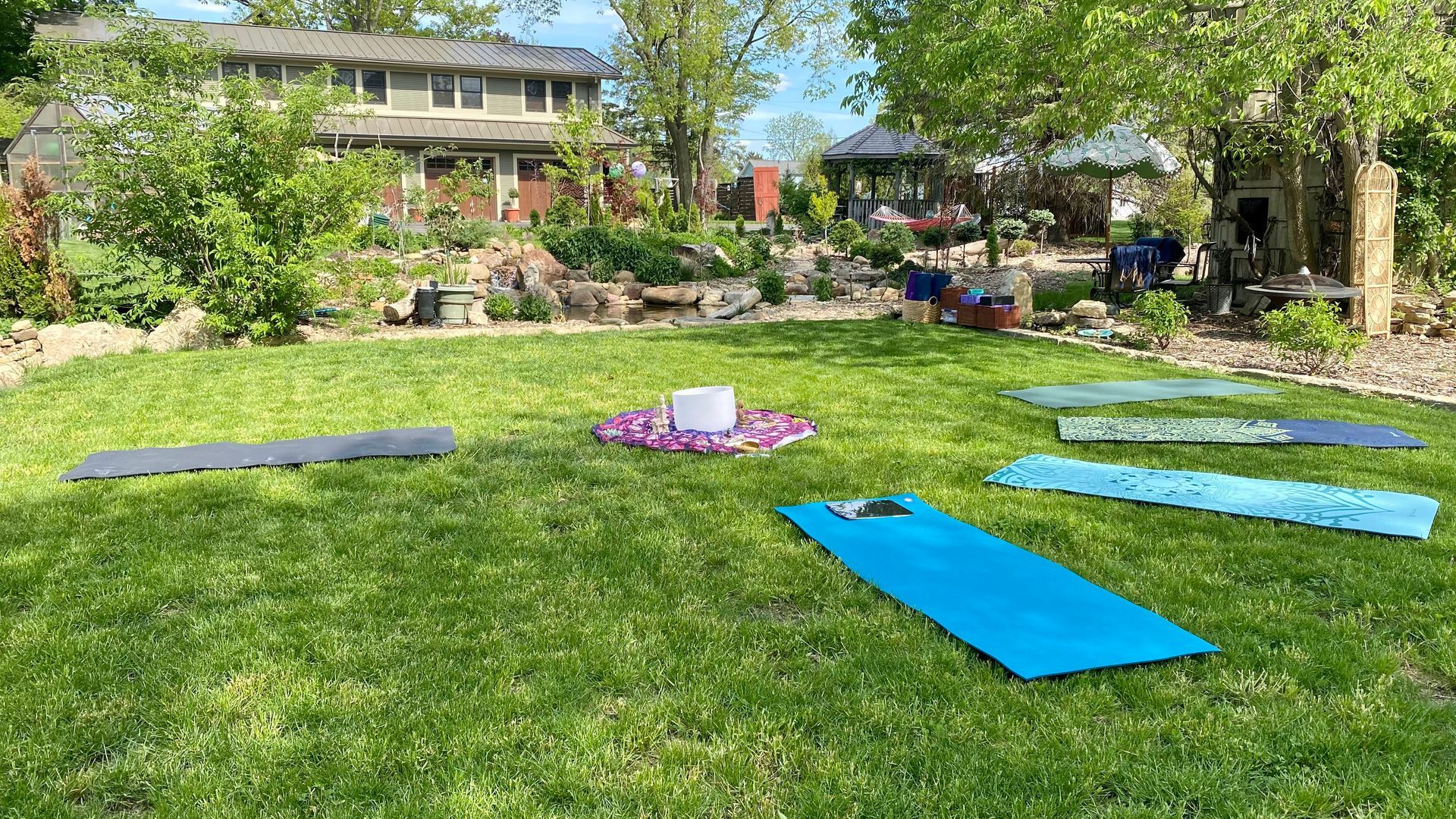 A group of yoga mats are sitting on top of a lush green lawn.