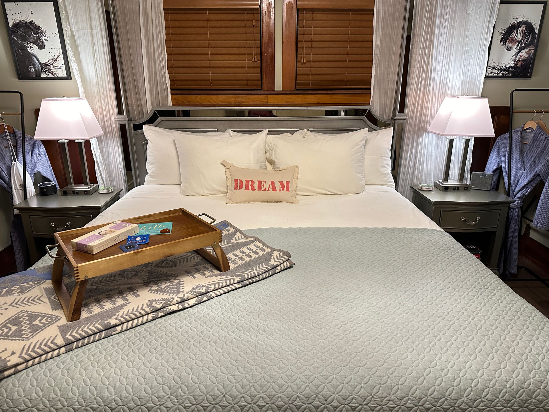 A bed with a tray on it and a pillow that says `` dream ''.
