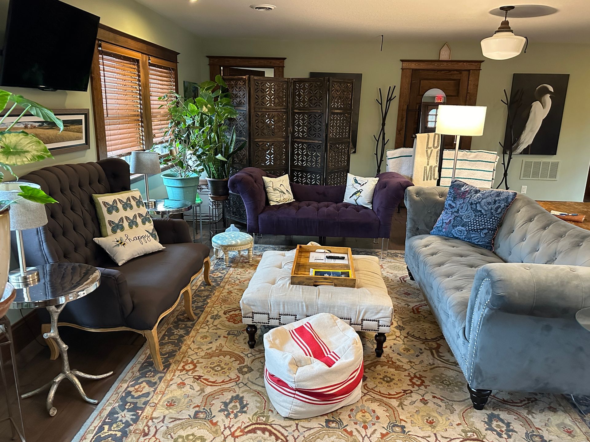 A living room with a purple couch and a gray couch