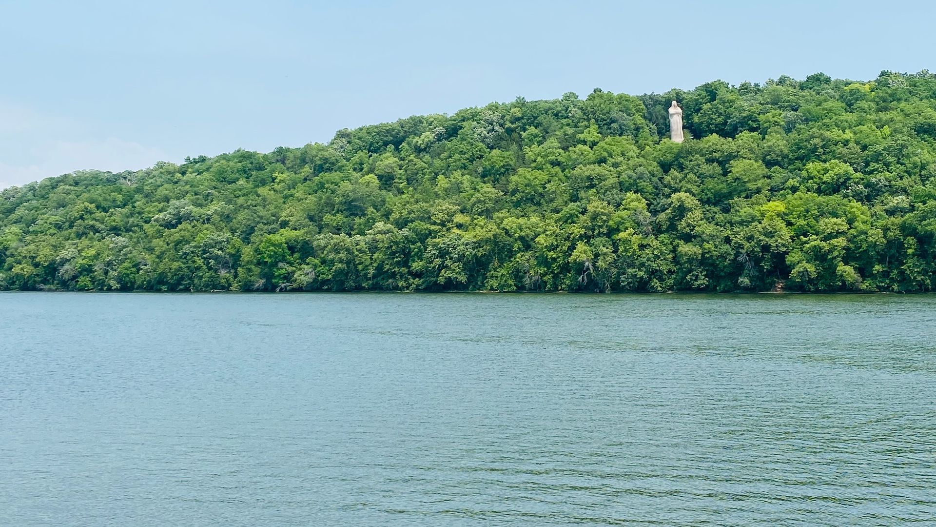 A large body of water surrounded by trees on a hillside