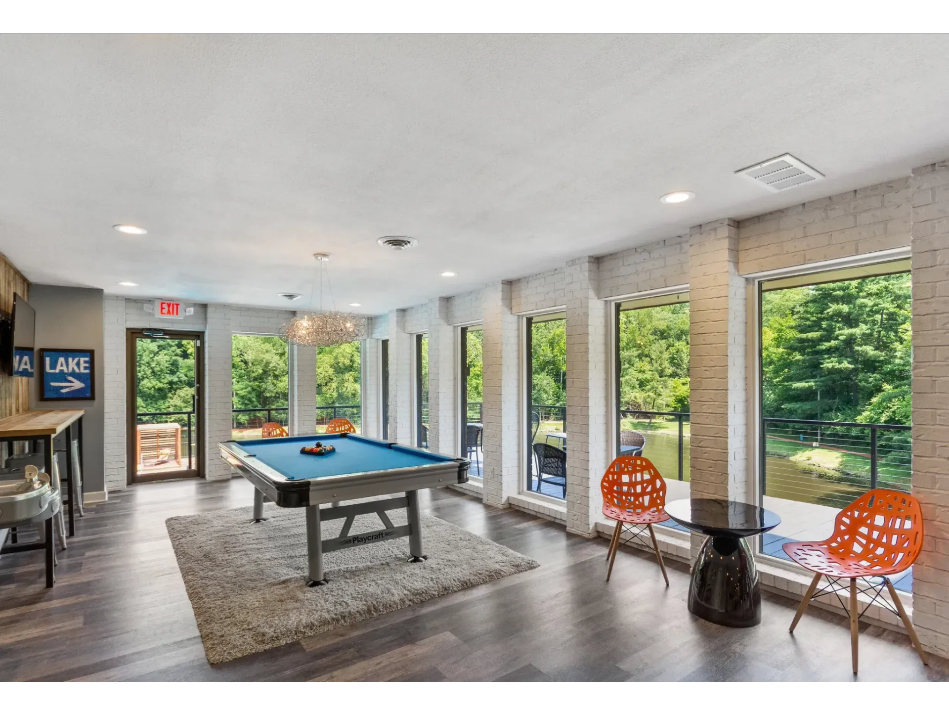 Modern common area with pool table and large windows overlooking greenery