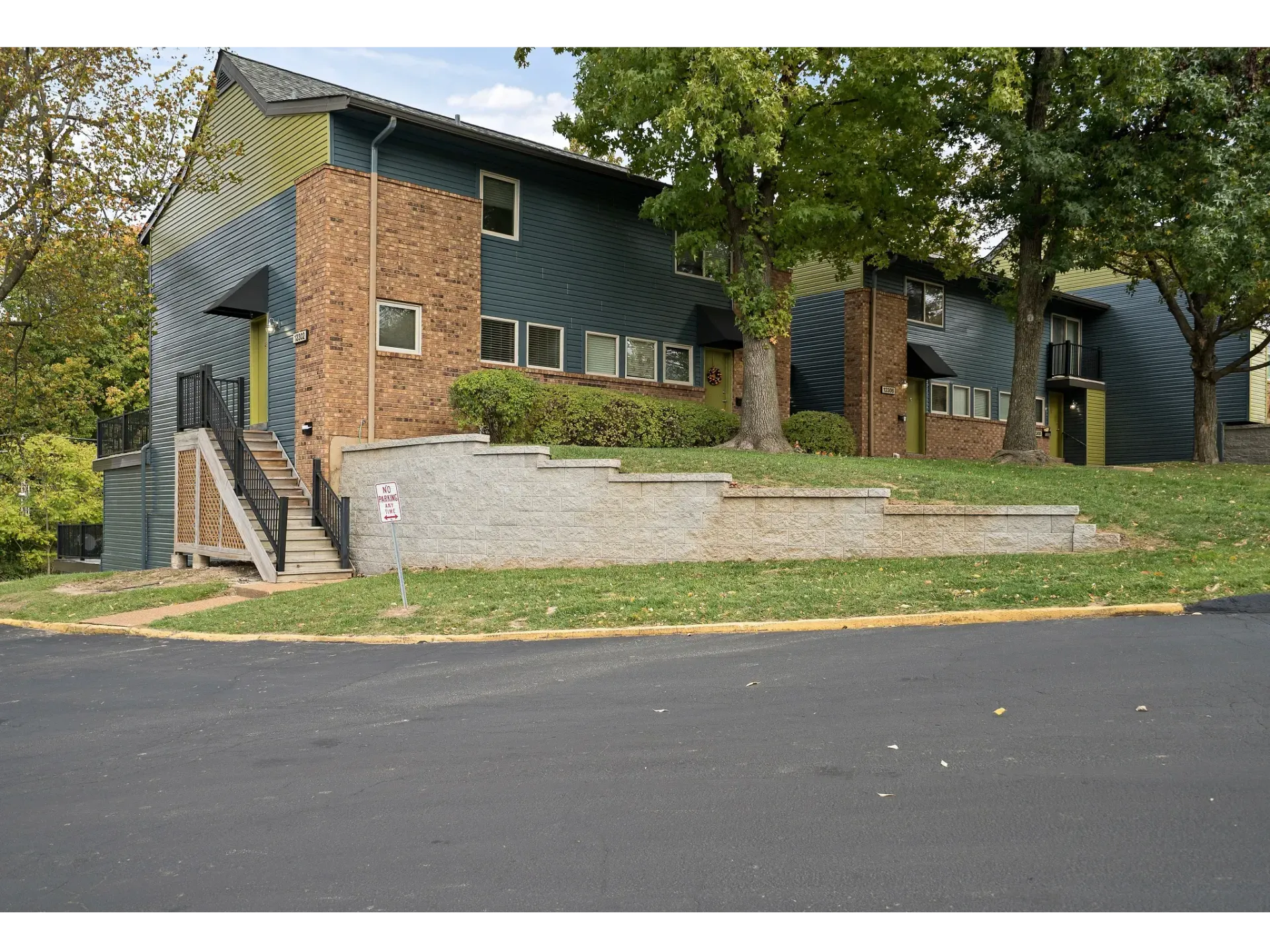 Exterior view of an apartment building with landscaping and stairs