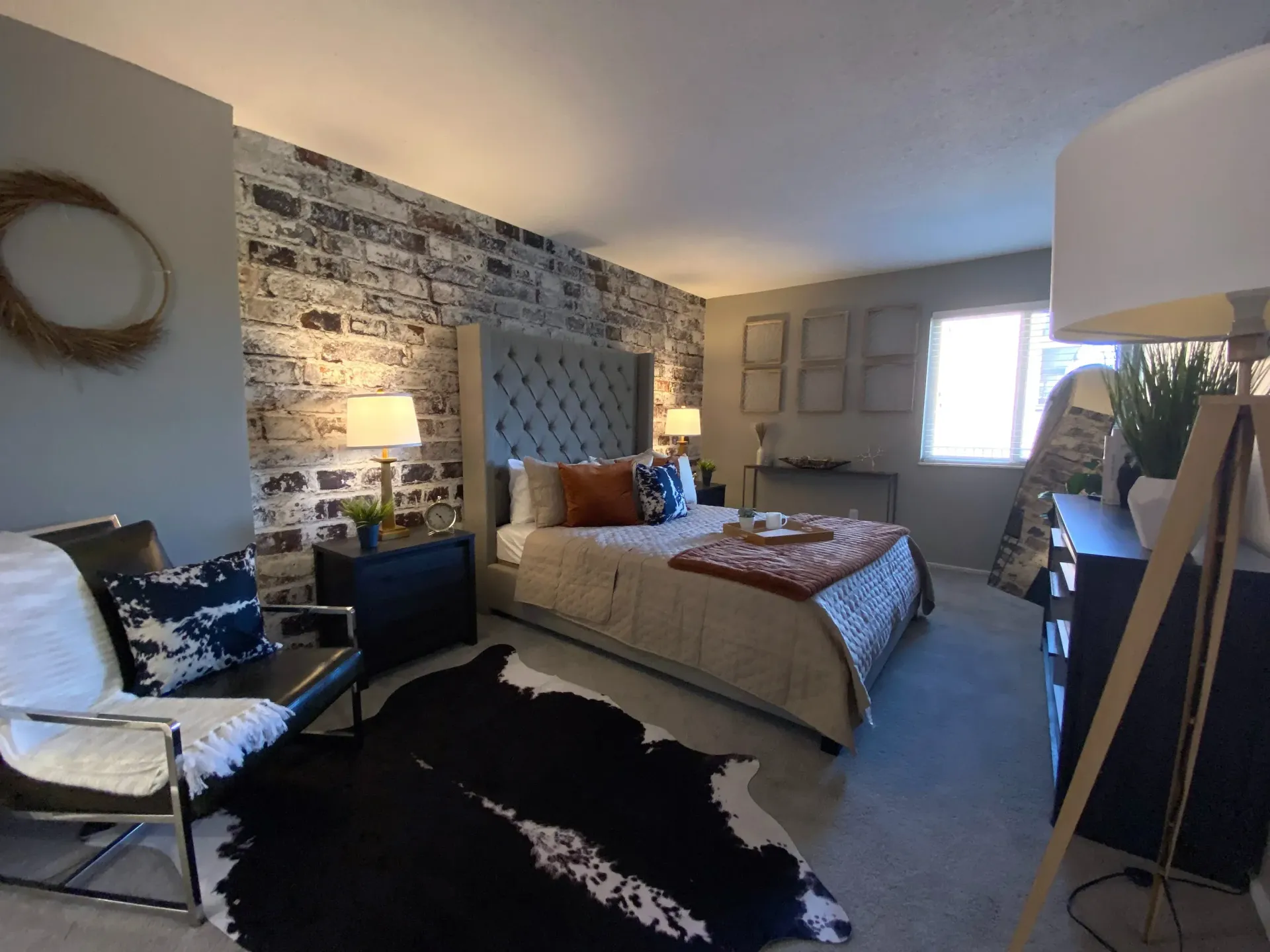 A stylish bedroom featuring a tufted headboard, modern decor, and a cozy atmosphere.