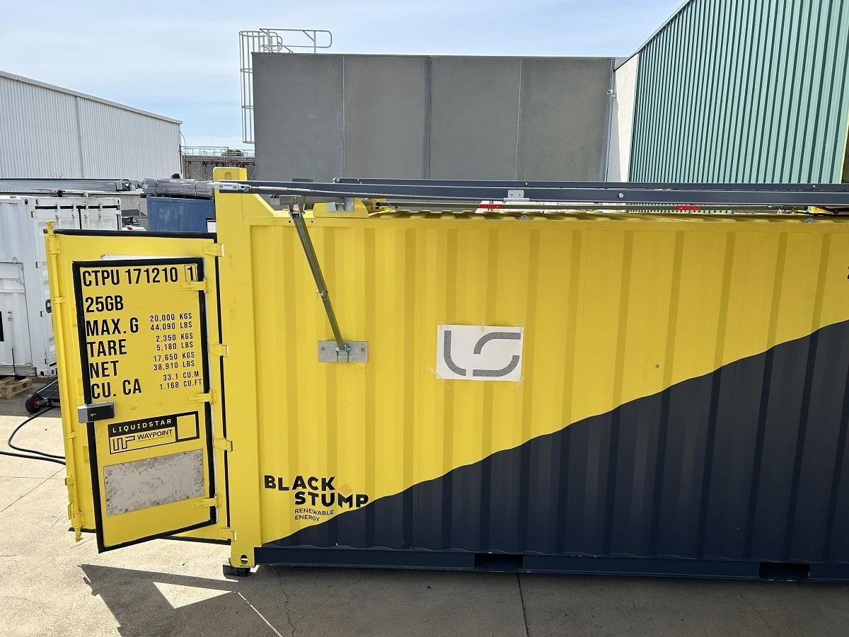 Yellow and black shipping container with open door; logo visible. Other containers in background.