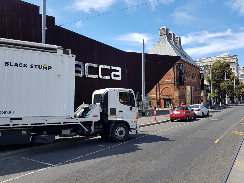 Truck parked on street in front of the ACCA building, a modern art gallery in Melbourne, Australia.