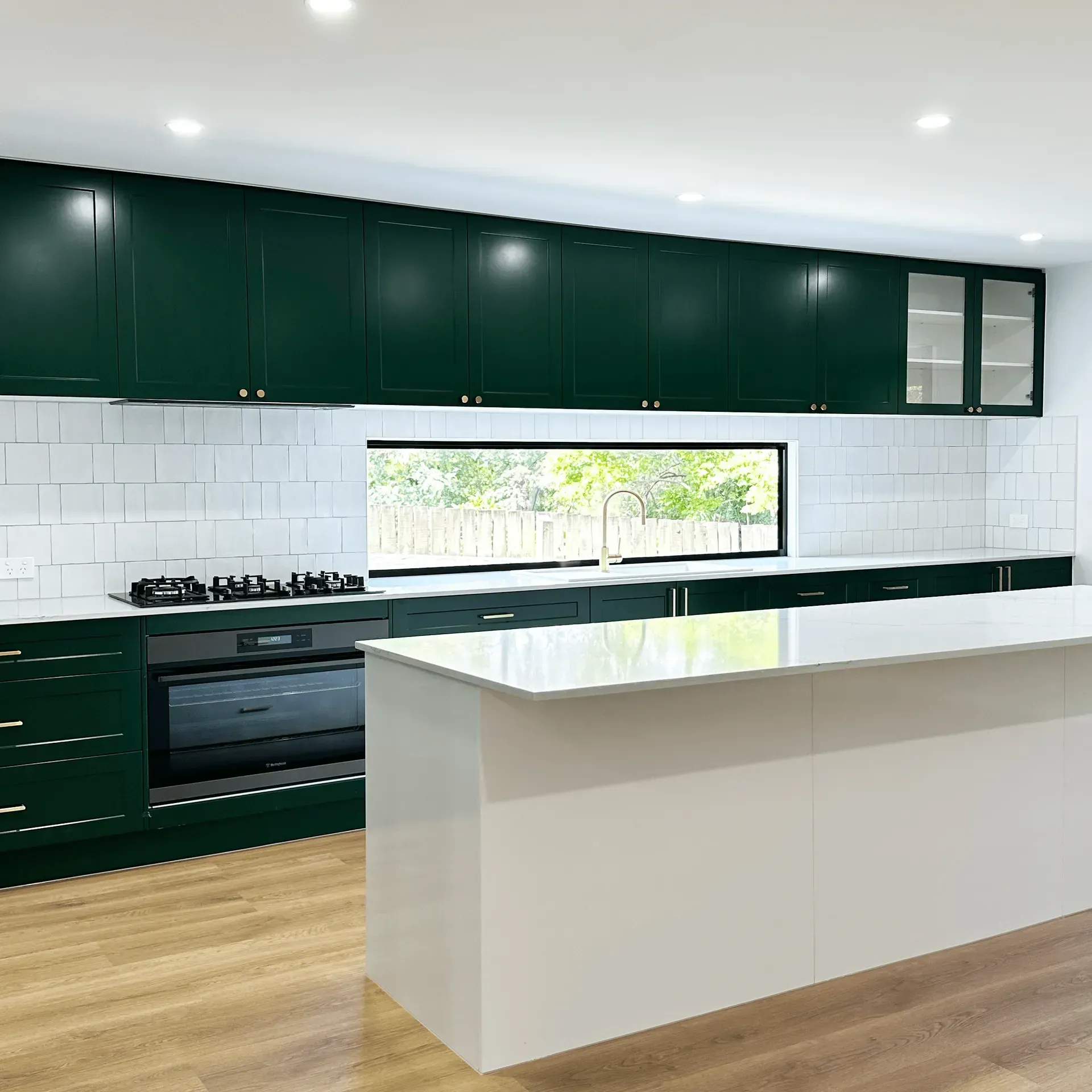 A kitchen with a large island and a wine cooler.