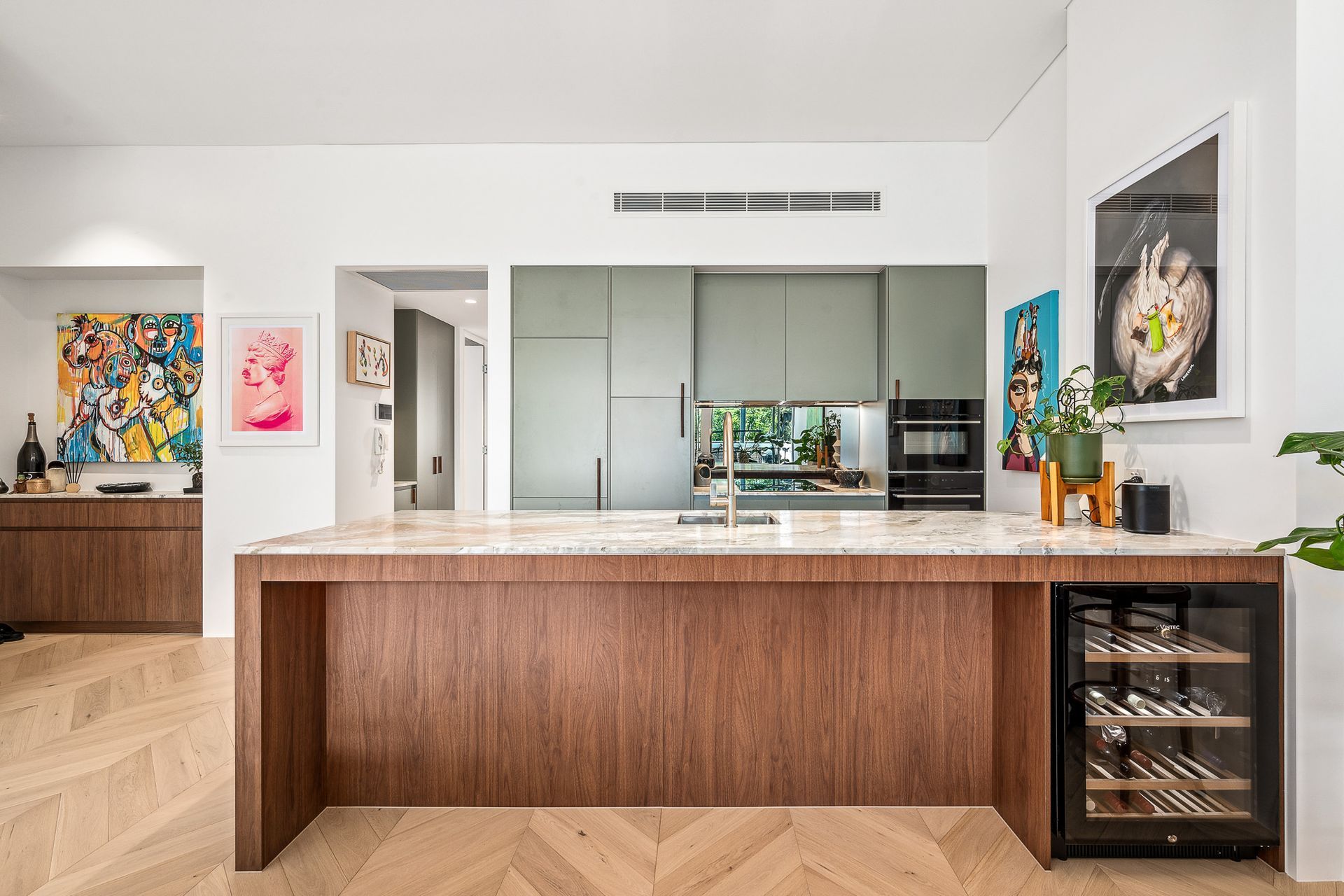 A kitchen with a large island and a wine cooler.