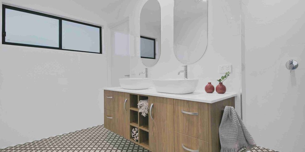 A bathroom with two sinks and two mirrors.