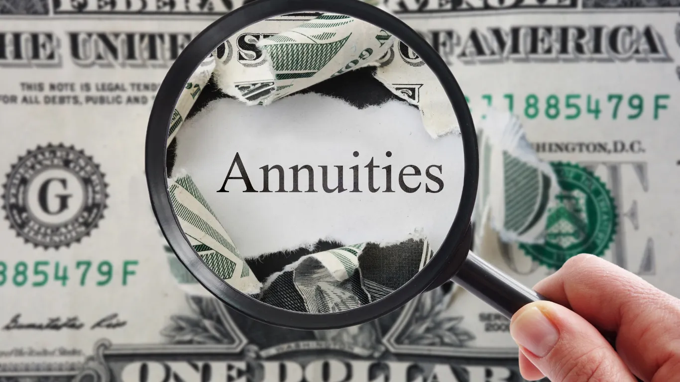 A magnifying glass shows the word annuities on a dollar bill