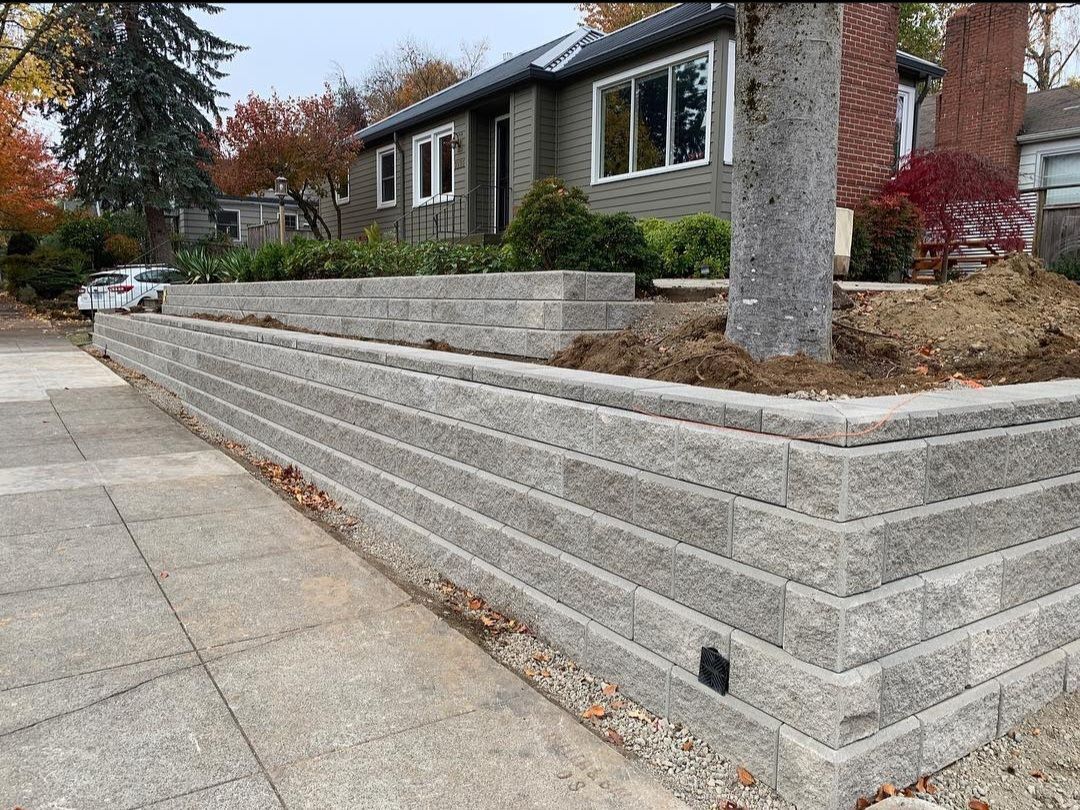 A brick wall is being built in front of a house.