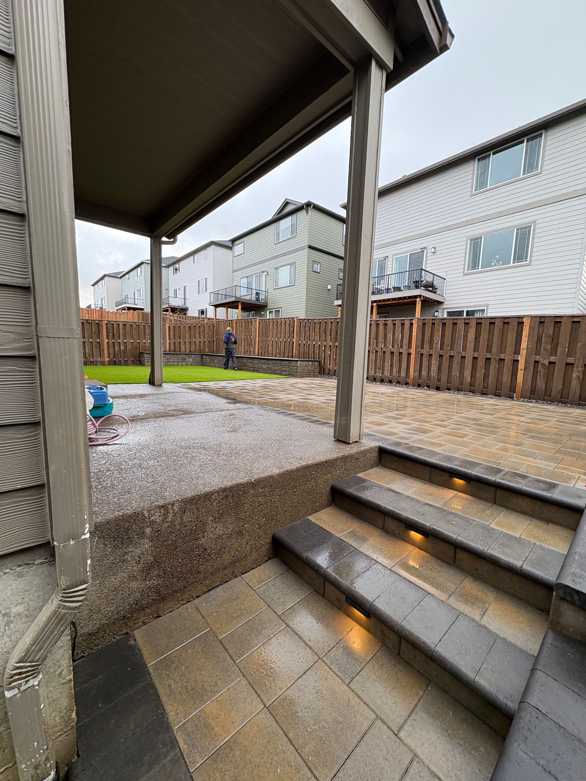 There are stairs leading up to the backyard of a house.