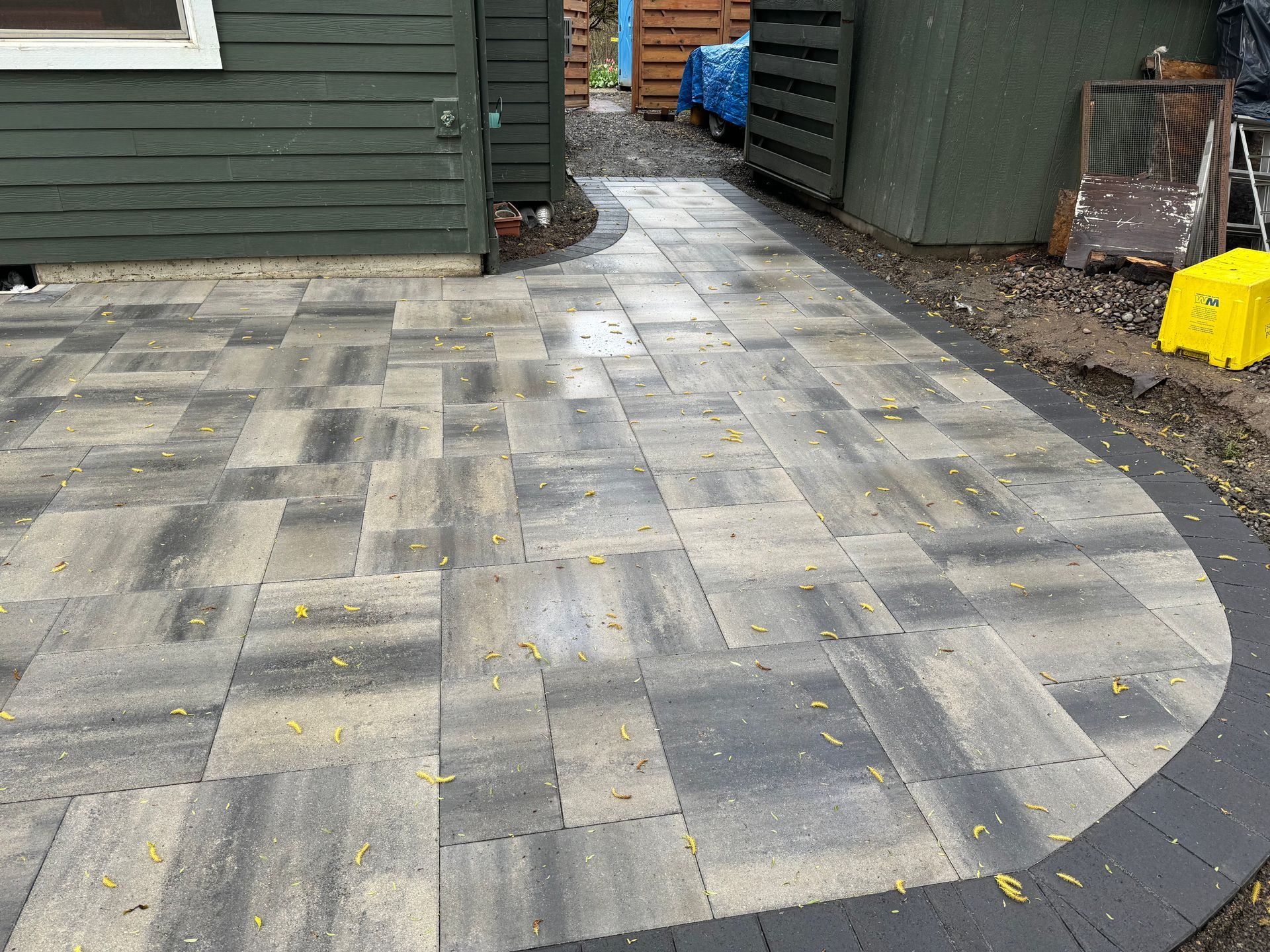 A patio with a walkway leading to a green house.
