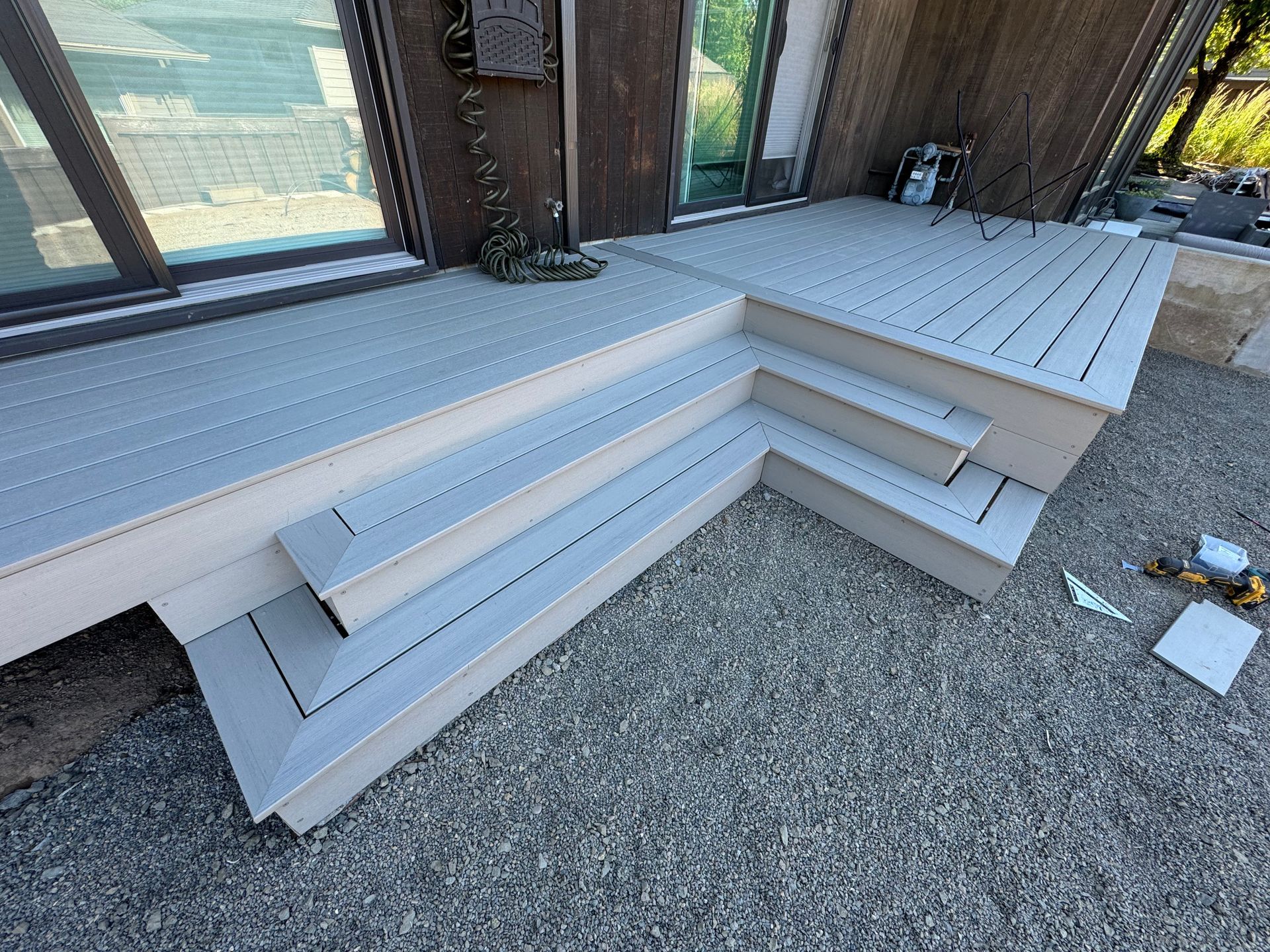 A deck with stairs leading up to it is being built in front of a house.