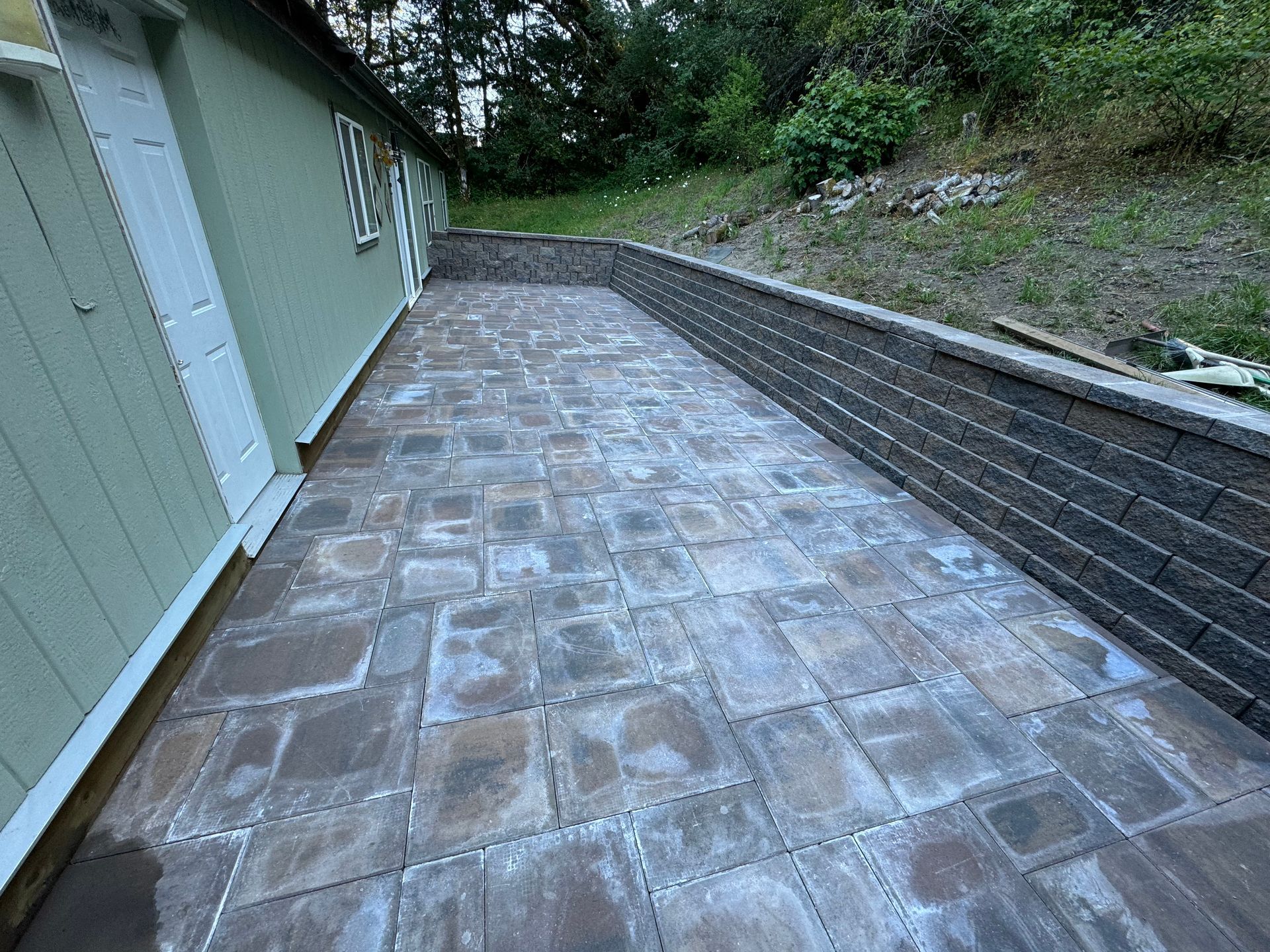 A brick walkway is being built next to a house.