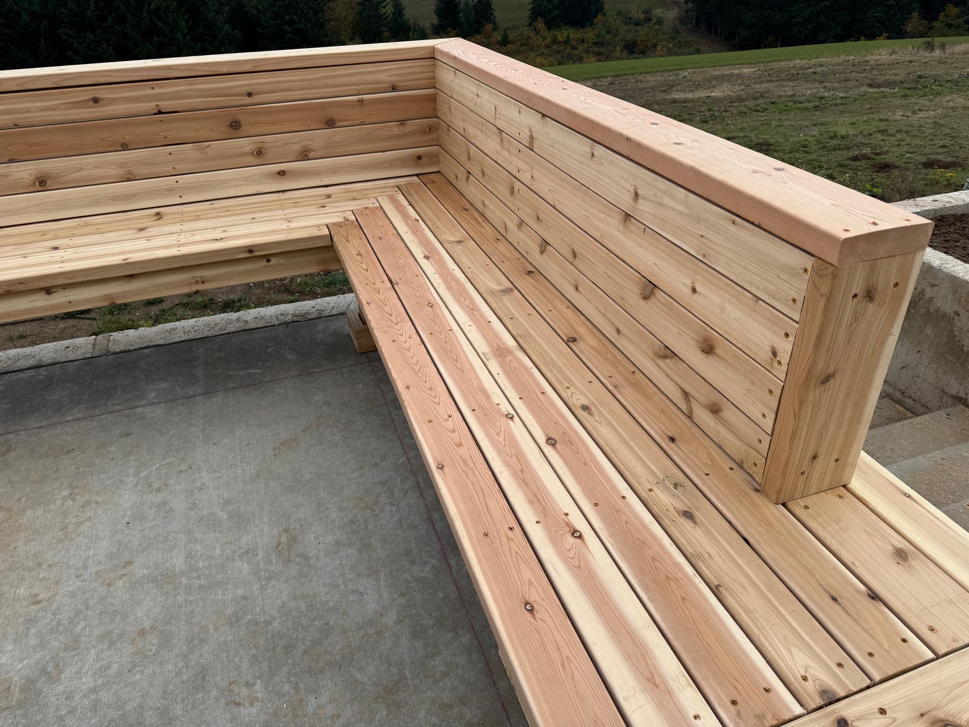 A wooden bench is sitting on a concrete surface.