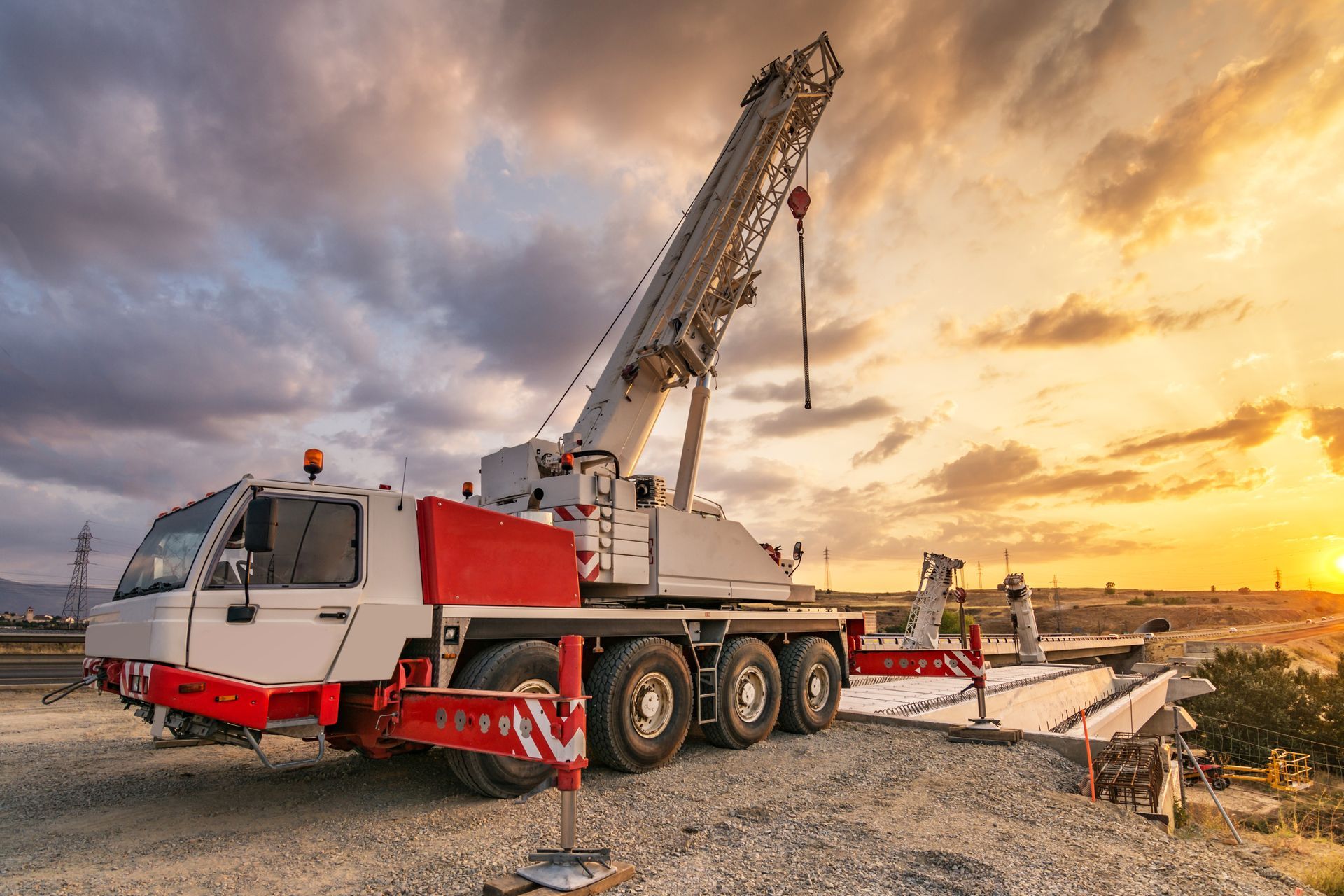 Mobile crane rental featuring a truck-mounted crane at a bridge construction site.