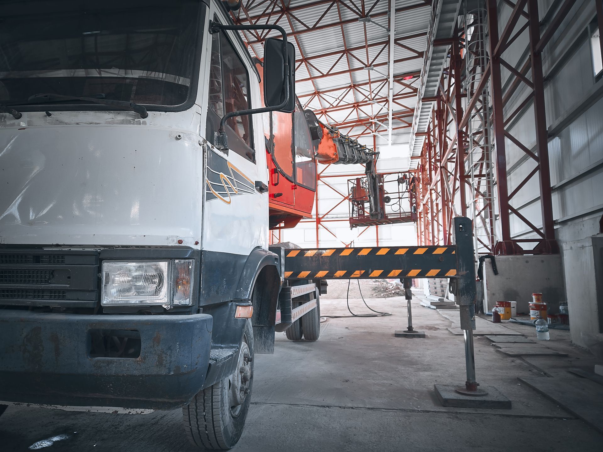 Truck crane rental featuring an articulated boom truck operating inside an industrial facility. Truck crane rental featuring an articulated boom truck operating inside an industrial facility.