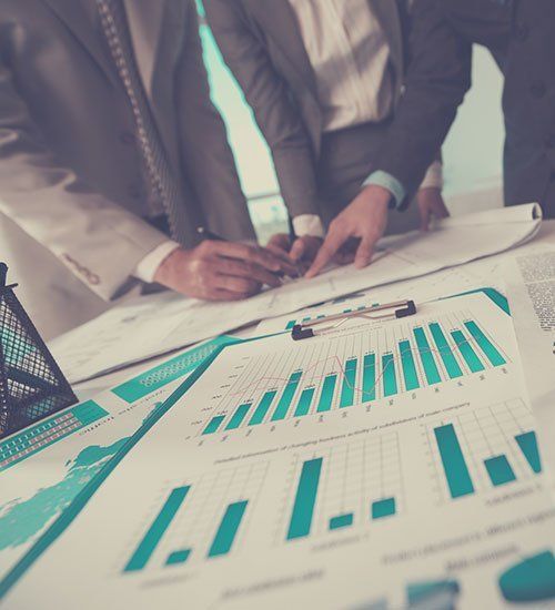 A group of people are looking at a graph on a table.