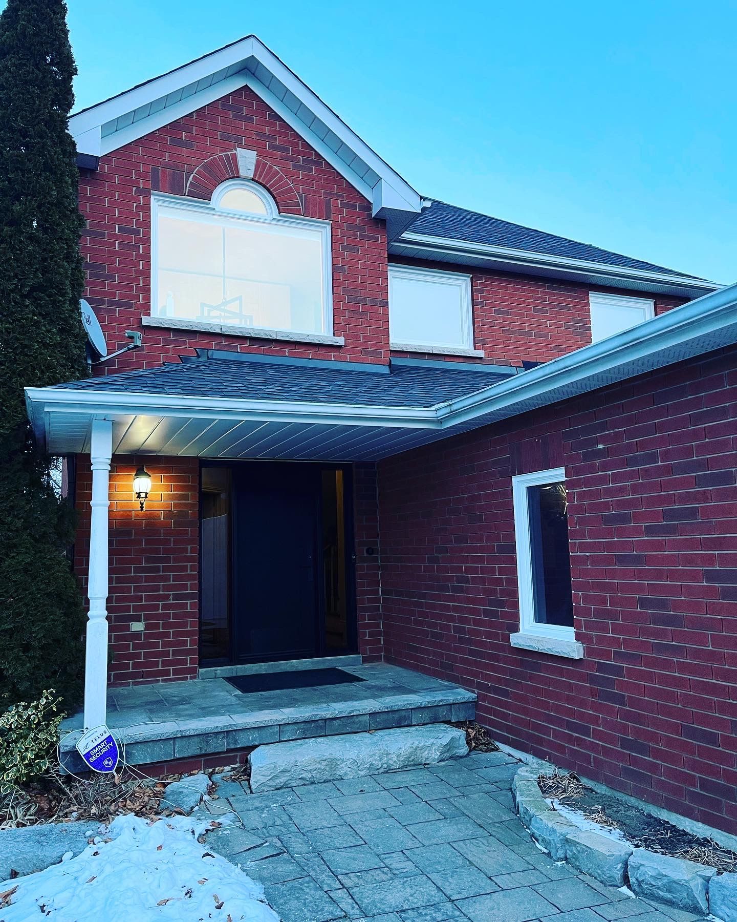A red brick house with a porch and stairs