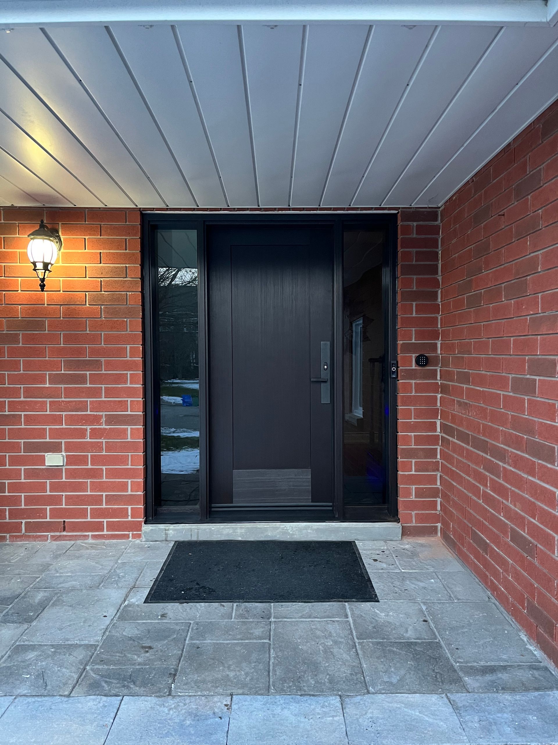 The front door of a brick house with a black door
