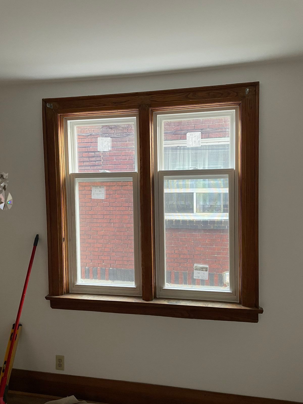 A window in a room with a brick building in the background