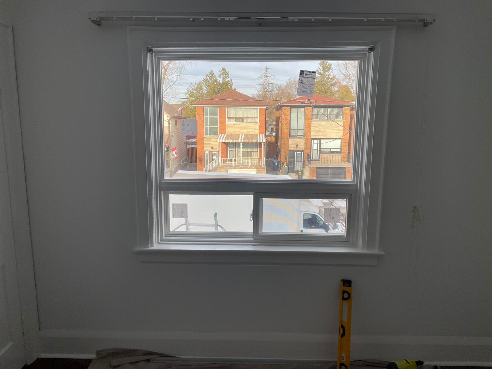 There is a window in the middle of a room with a view of a city.