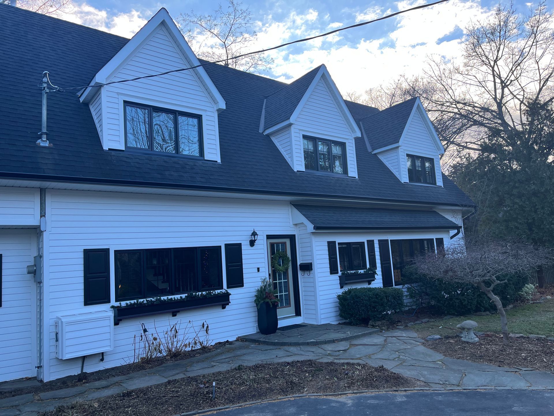A white house with a black roof and black windows