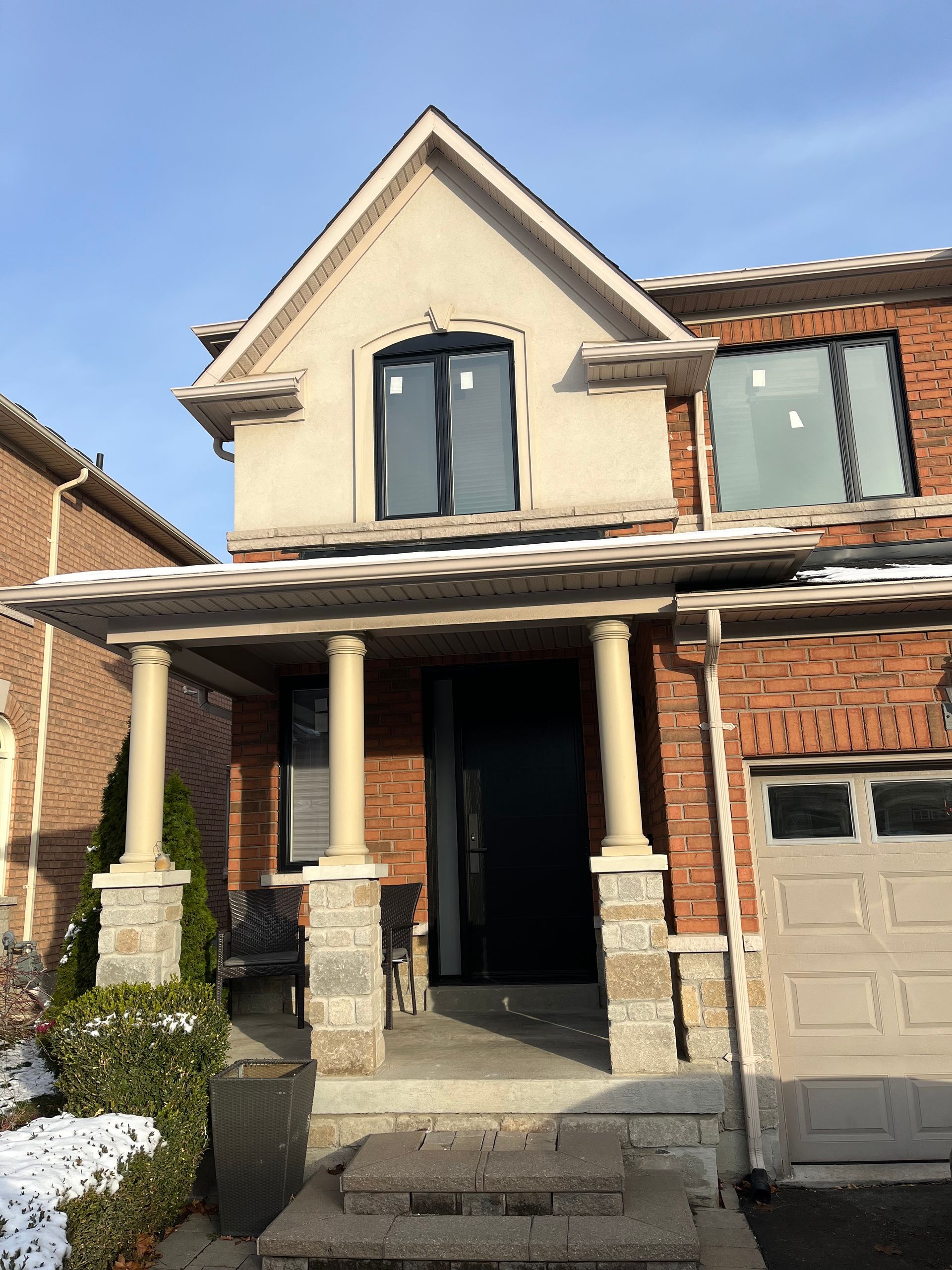 A brick house with a porch and a garage