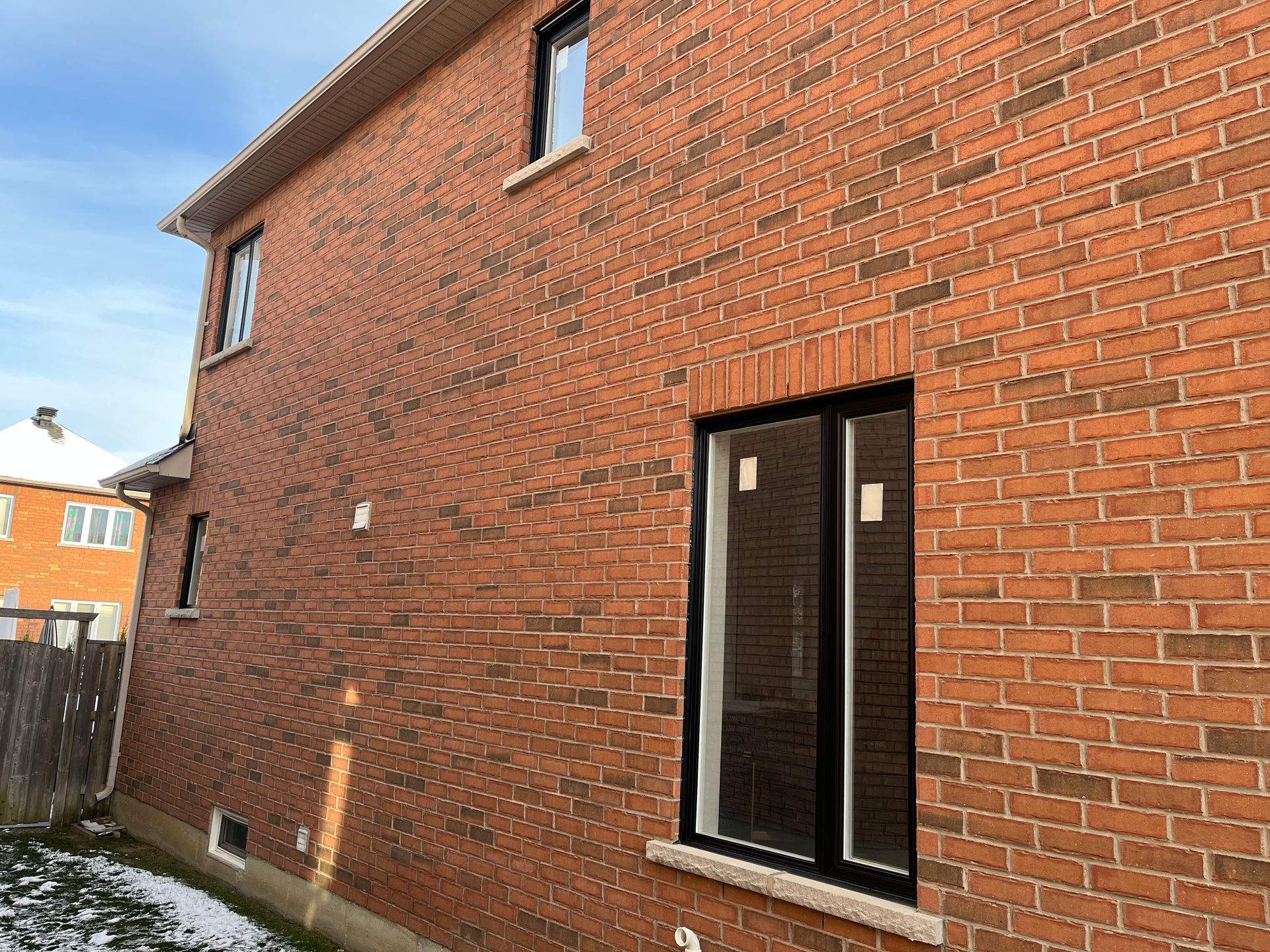 A brick house with a window on the side of it.