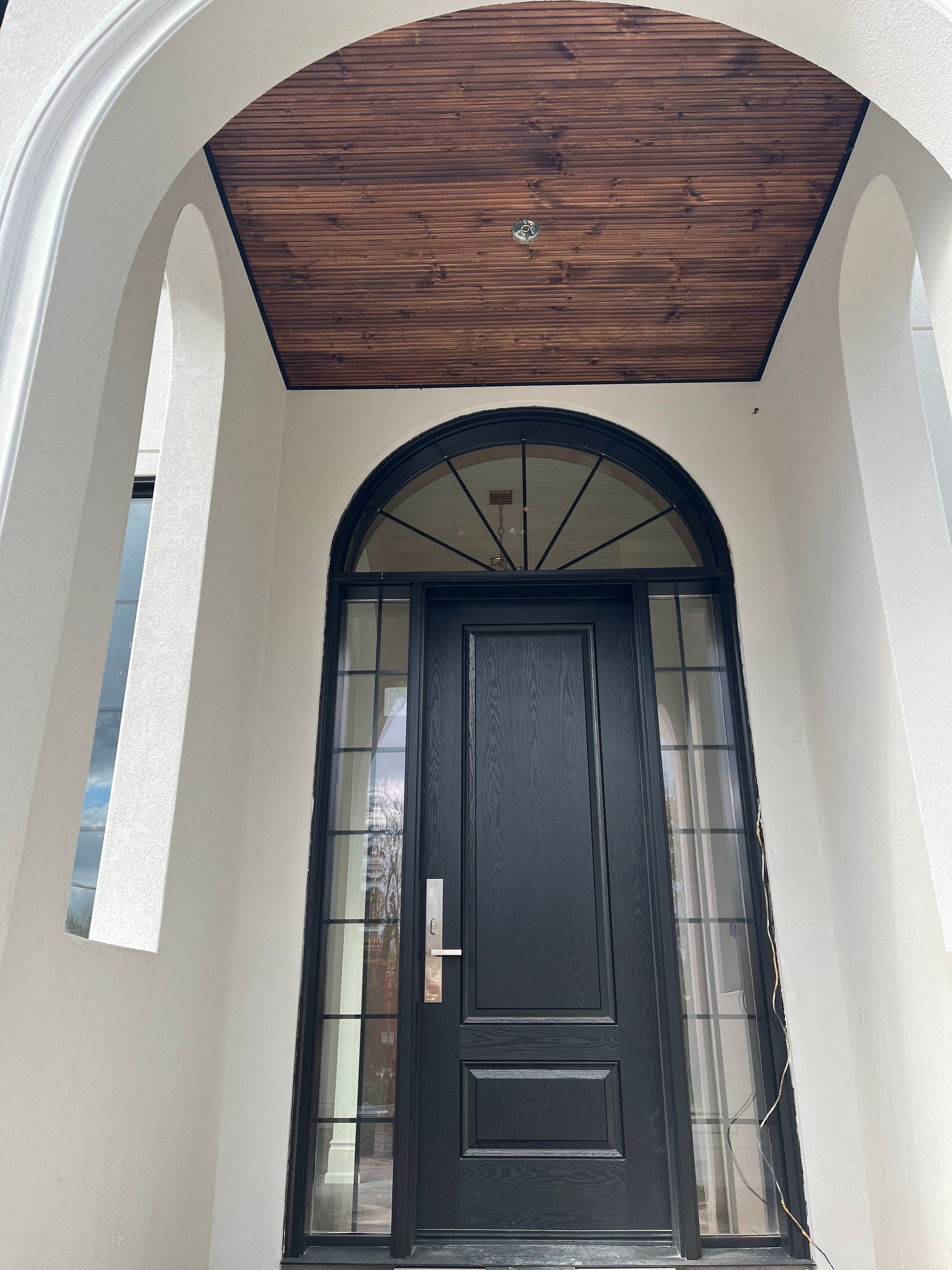 A black door with a wooden ceiling above it