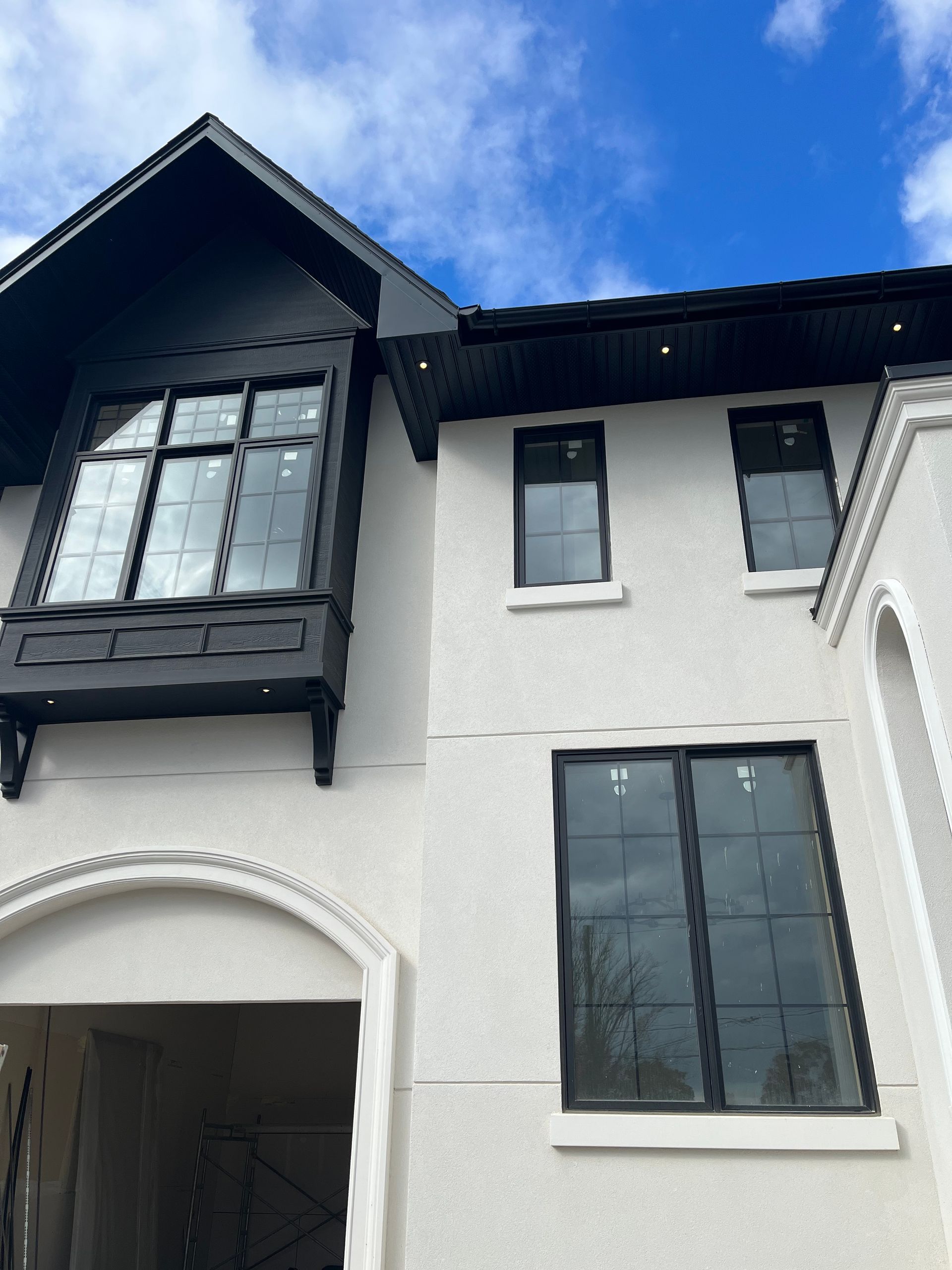 A white house with black windows and a blue sky in the background