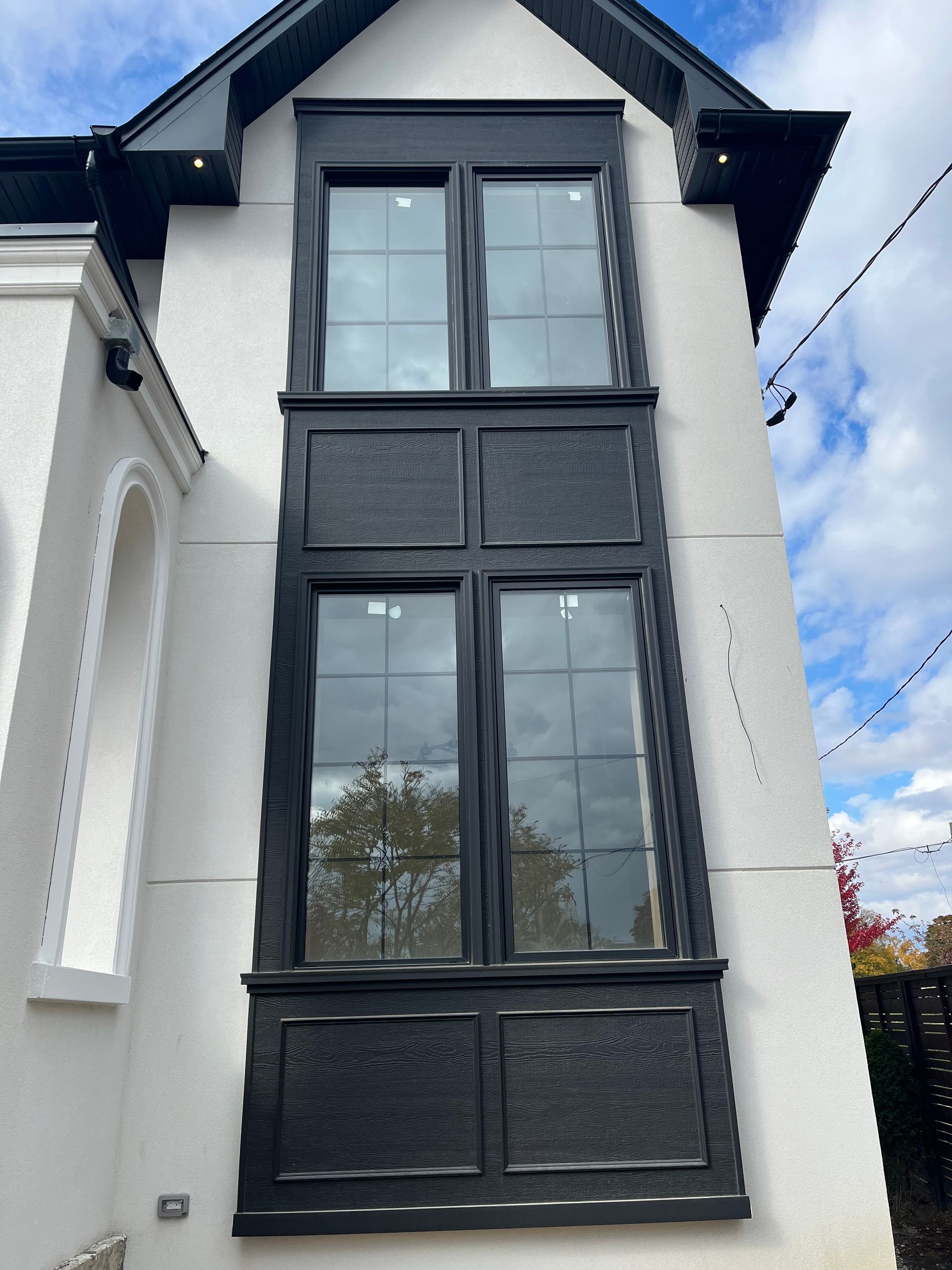 A white building with black windows and a blue sky in the background