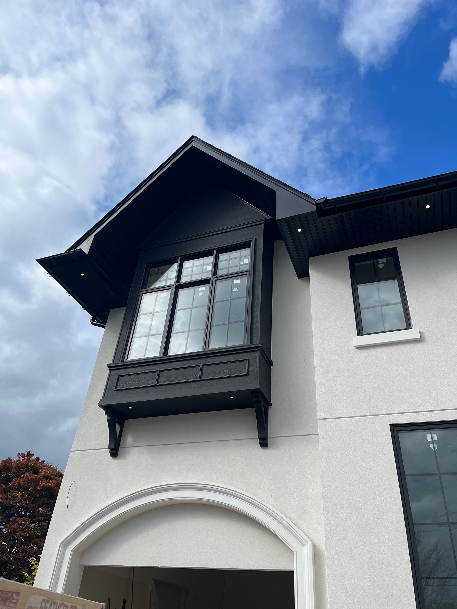 A white house with black windows and a blue sky in the background