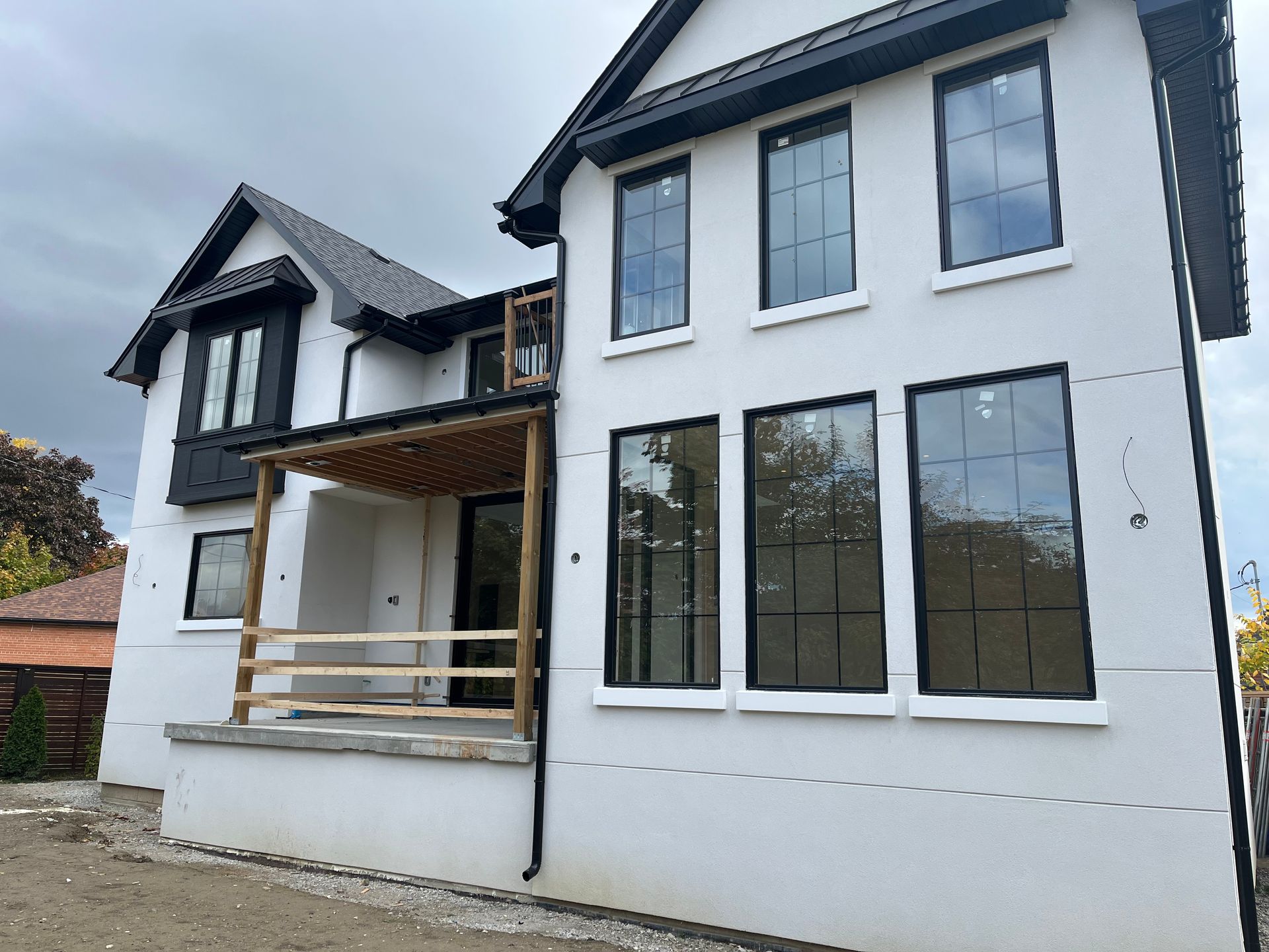 A white house with black windows is under construction.