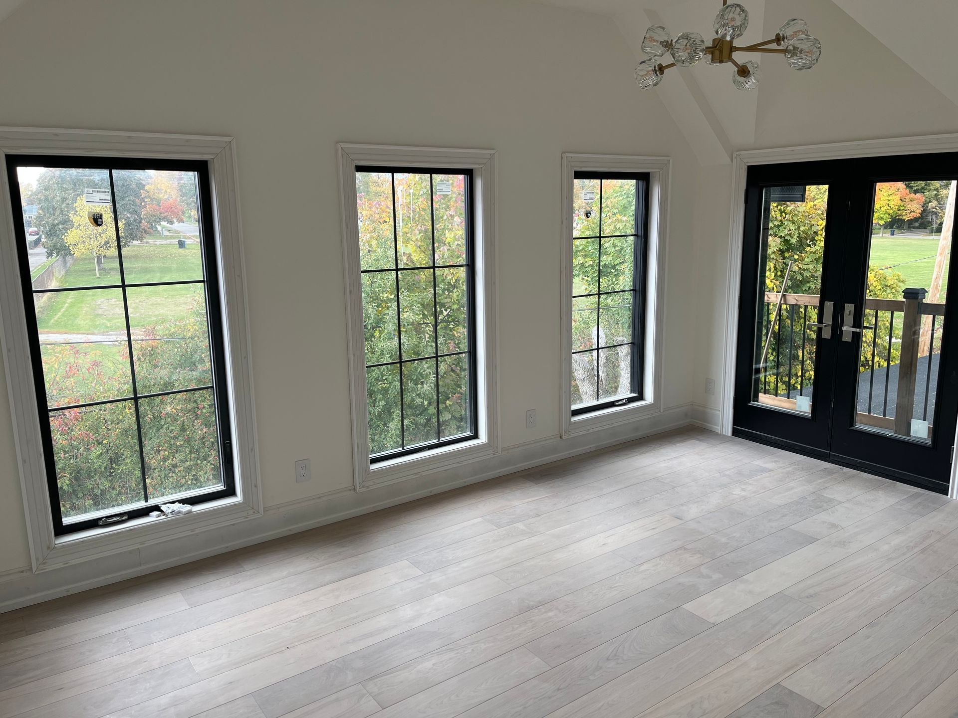 An empty room with a lot of windows and sliding glass doors.