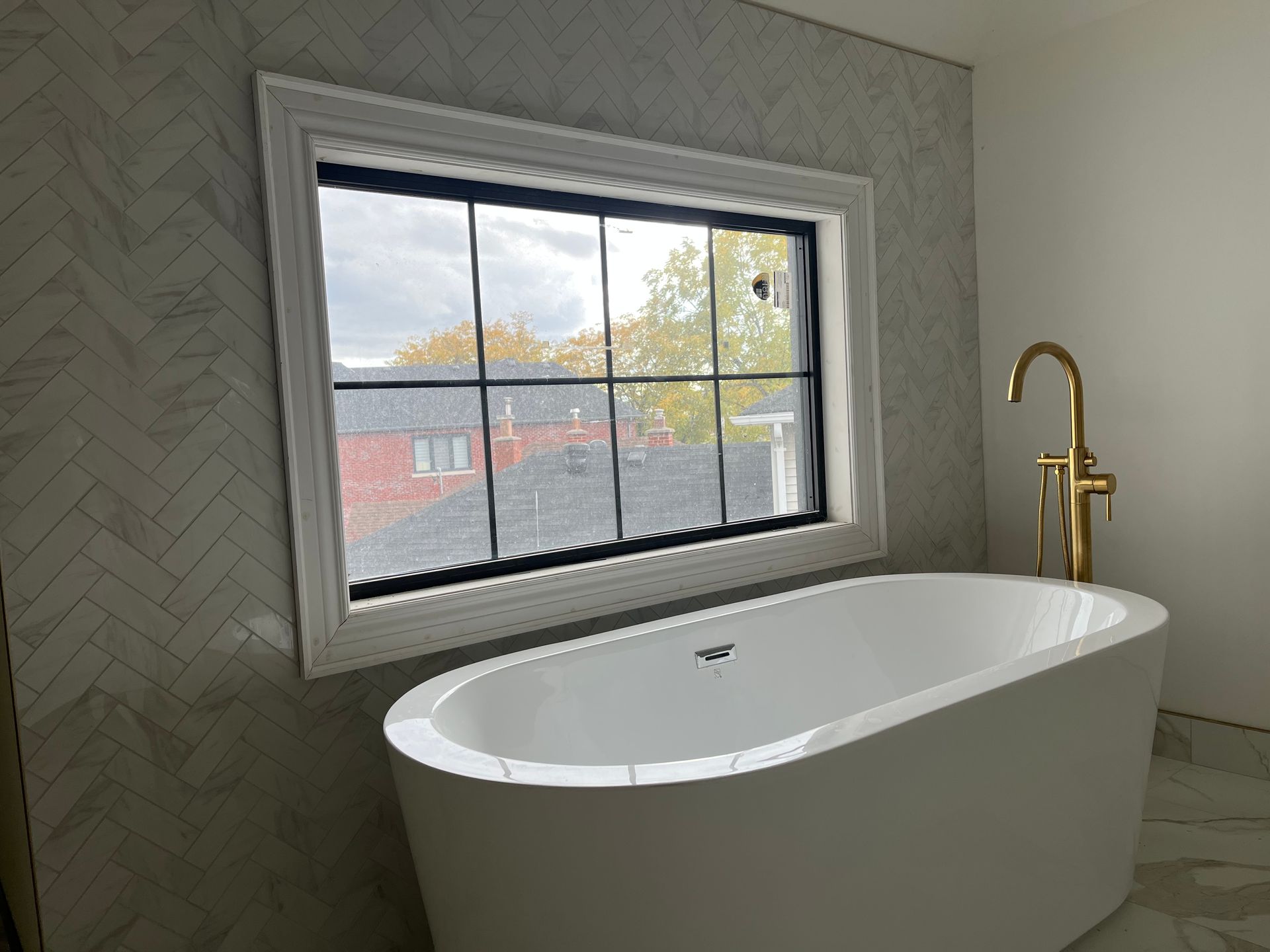 A bathtub in a bathroom next to a window.