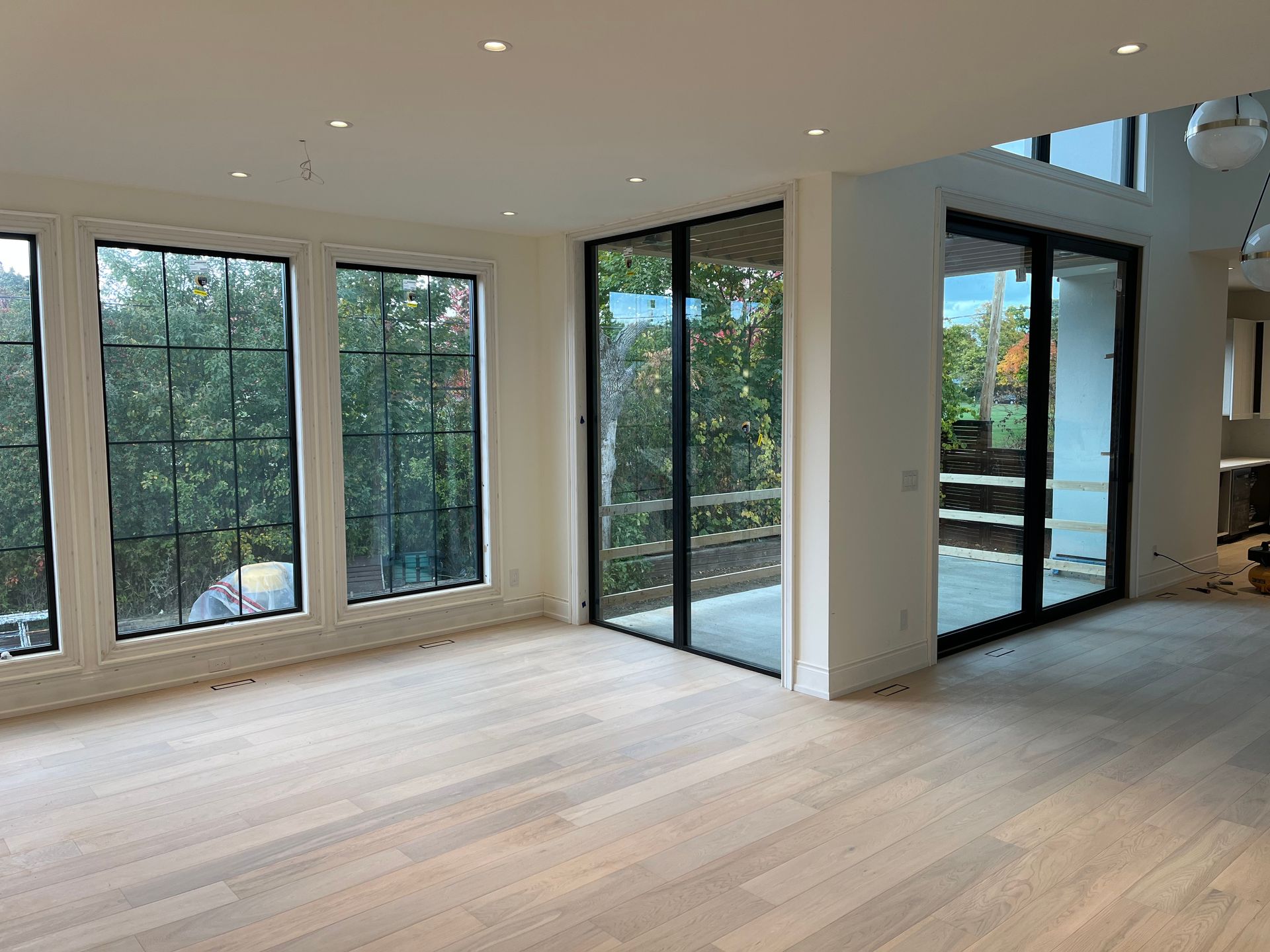 A large empty room with lots of windows and sliding glass doors.