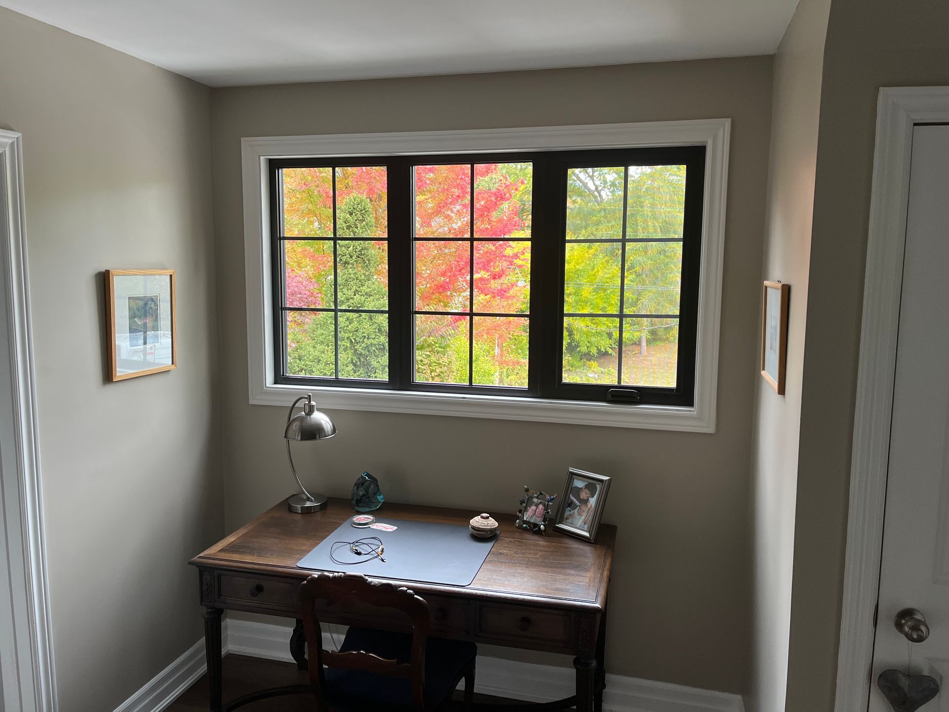 A room with a desk and chair in front of a window.