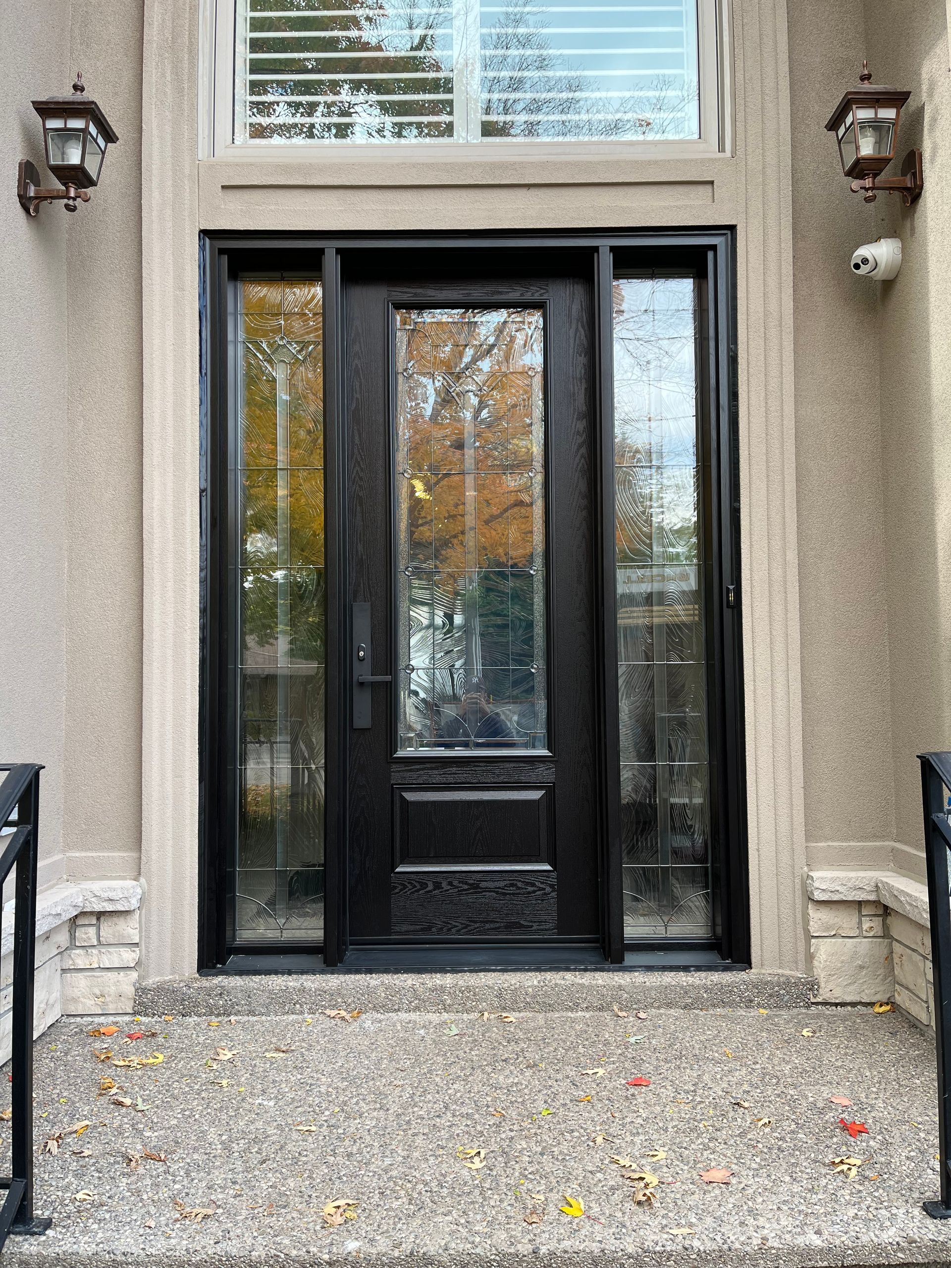 The front door of a house with a black door and a window.